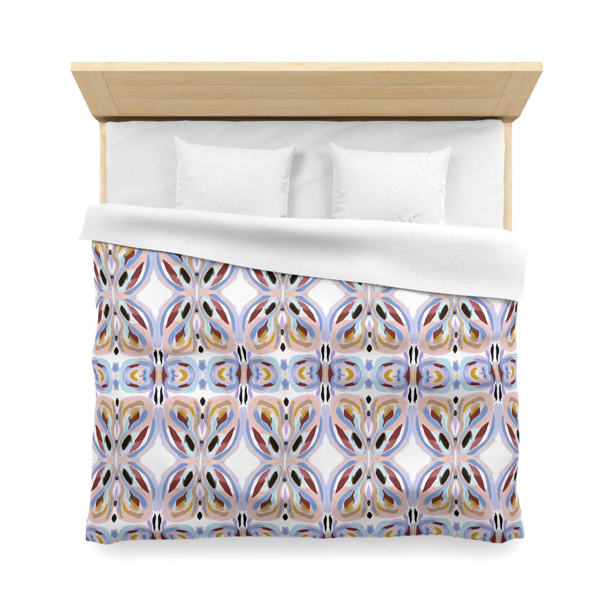a bed with a colorful, patterned comforter and pillows.