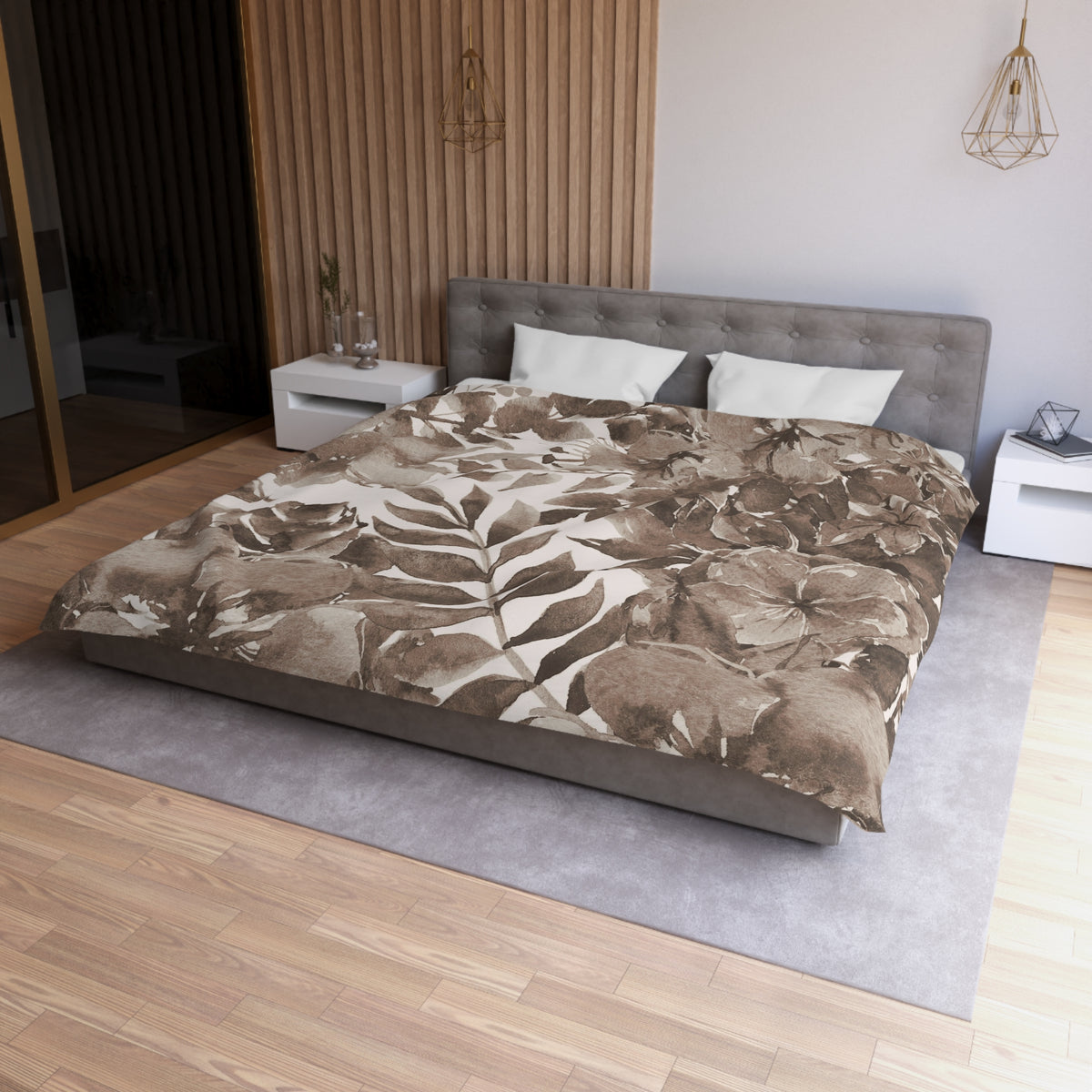 a modern bedroom with a large bed, a gray headboard, and a wooden wall. The bed is covered in a brown and white floral comforter, and there are two white pillows on the bed. The room has a wooden floor and a gray area rug. There are two nightstands on either side of the bed, and a pendant light hangs above the bed.