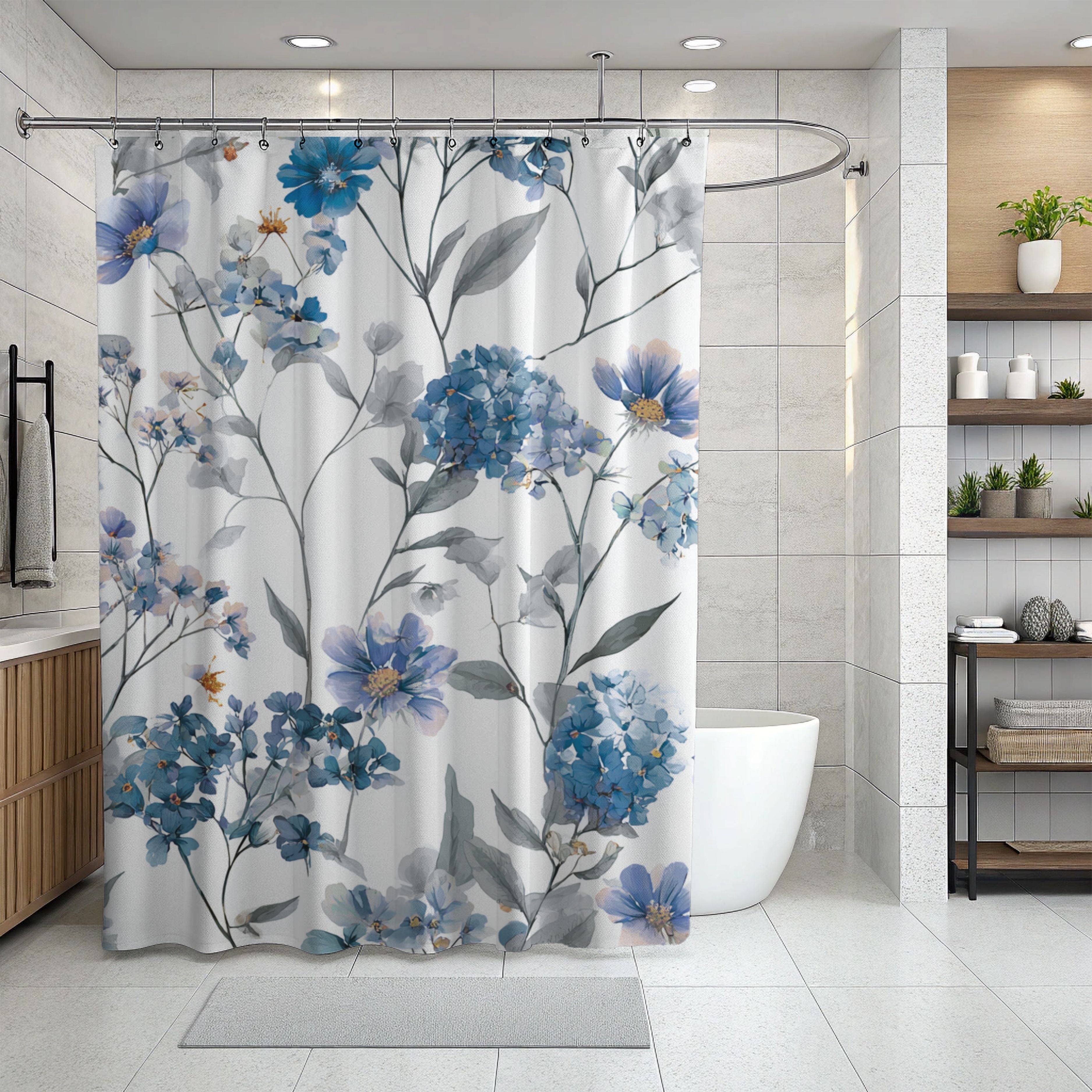 a modern bathroom with a shower curtain adorned with a floral pattern in shades of blue and gray. The shower curtain is hanging from a rod, and the bathroom has a white tiled floor and a white sink. There are also shelves and plants in the bathroom, adding to the overall aesthetic.