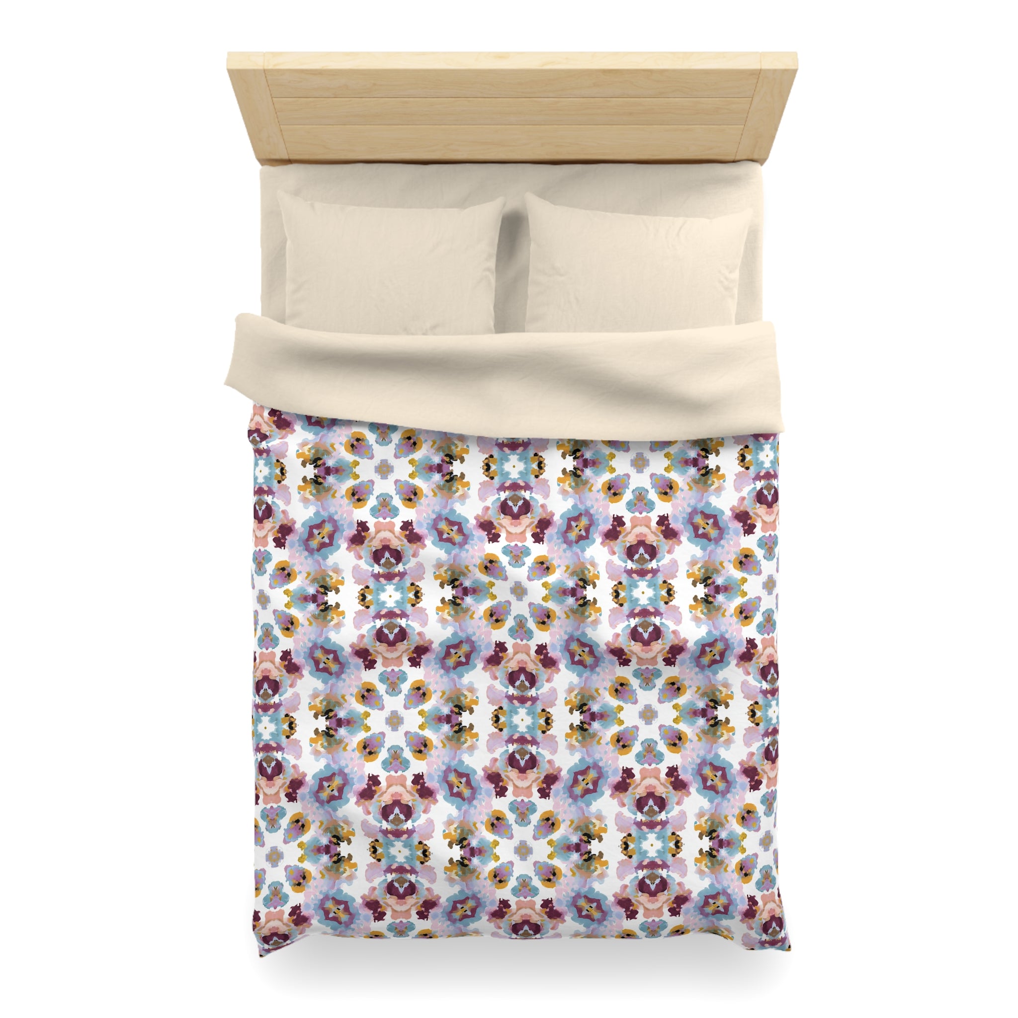 a neatly made bed with a colorful floral patterned comforter and pillows.