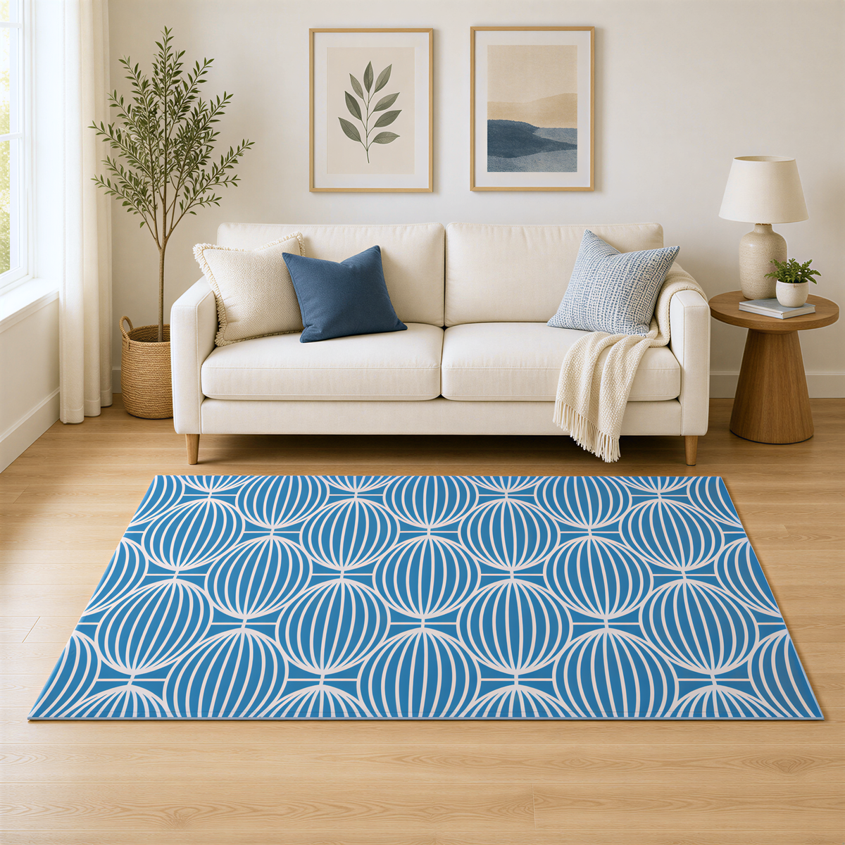 a cozy living room with a white sofa, a blue and white patterned rug, and two framed pictures on the wall.