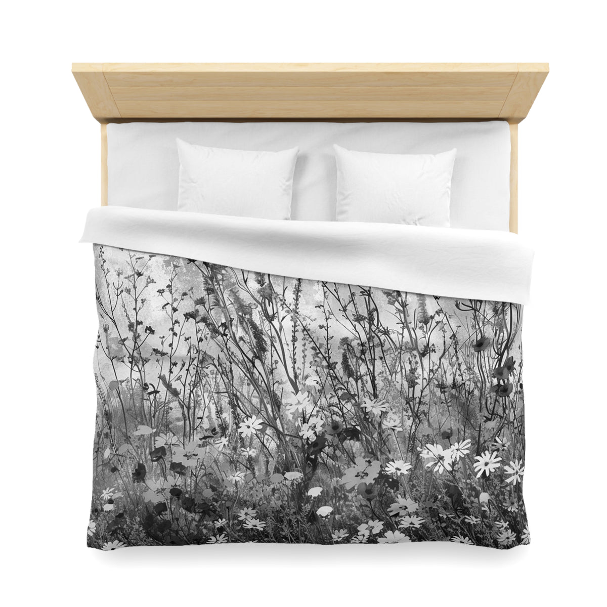a bed with a black and white floral patterned duvet cover and pillows.