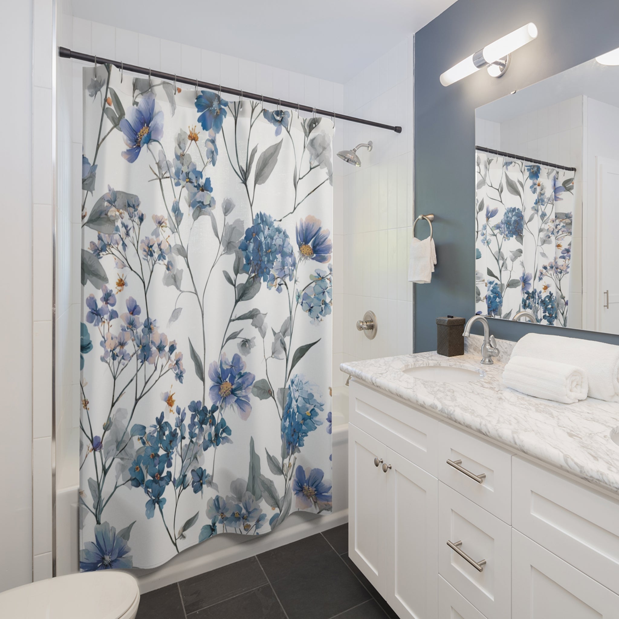A modern bathroom with a white vanity, a blue and white floral shower curtain, and a mirror above the sink.