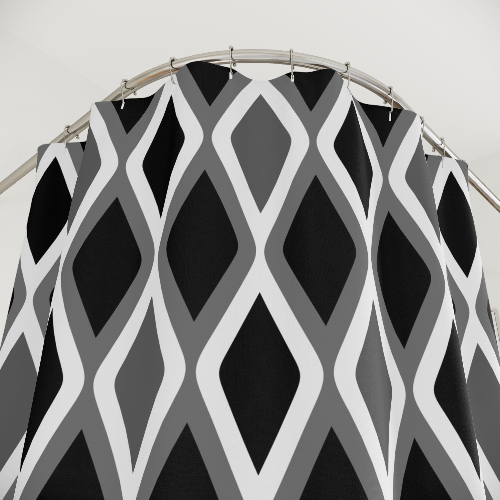 a black and white patterned shower curtain with a curved metal rod.