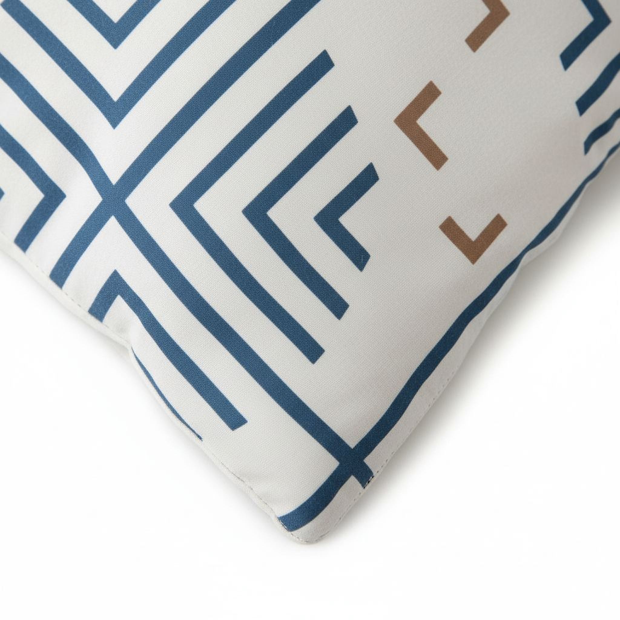 a close-up view of a white pillow with a geometric pattern in blue and brown colors.