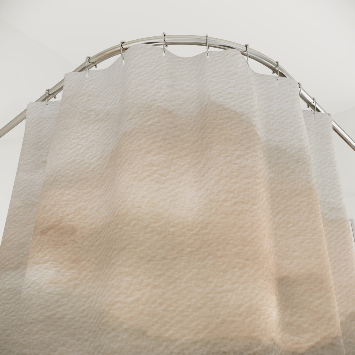 a shower curtain with a textured, beige-colored design hanging from a curved metal rod.