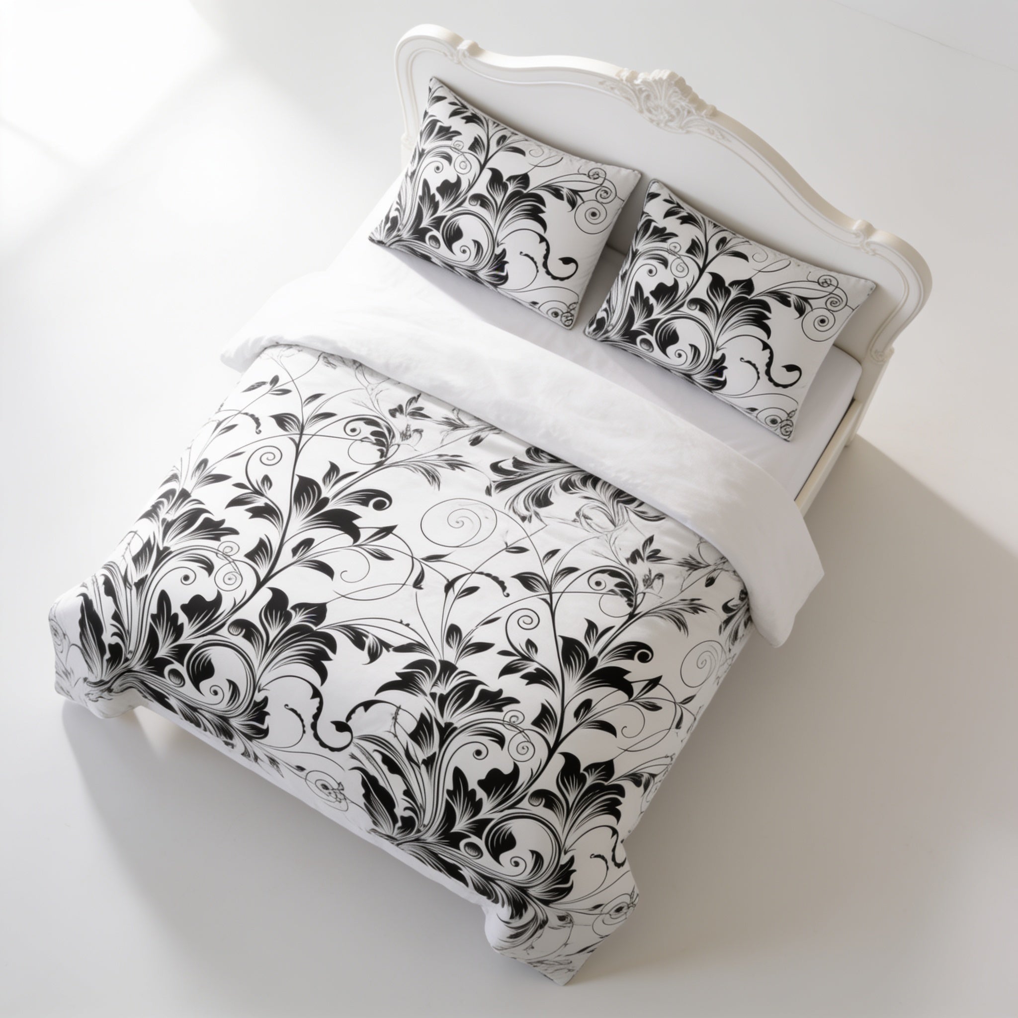 a white bed with a black and white floral patterned comforter and matching pillows.