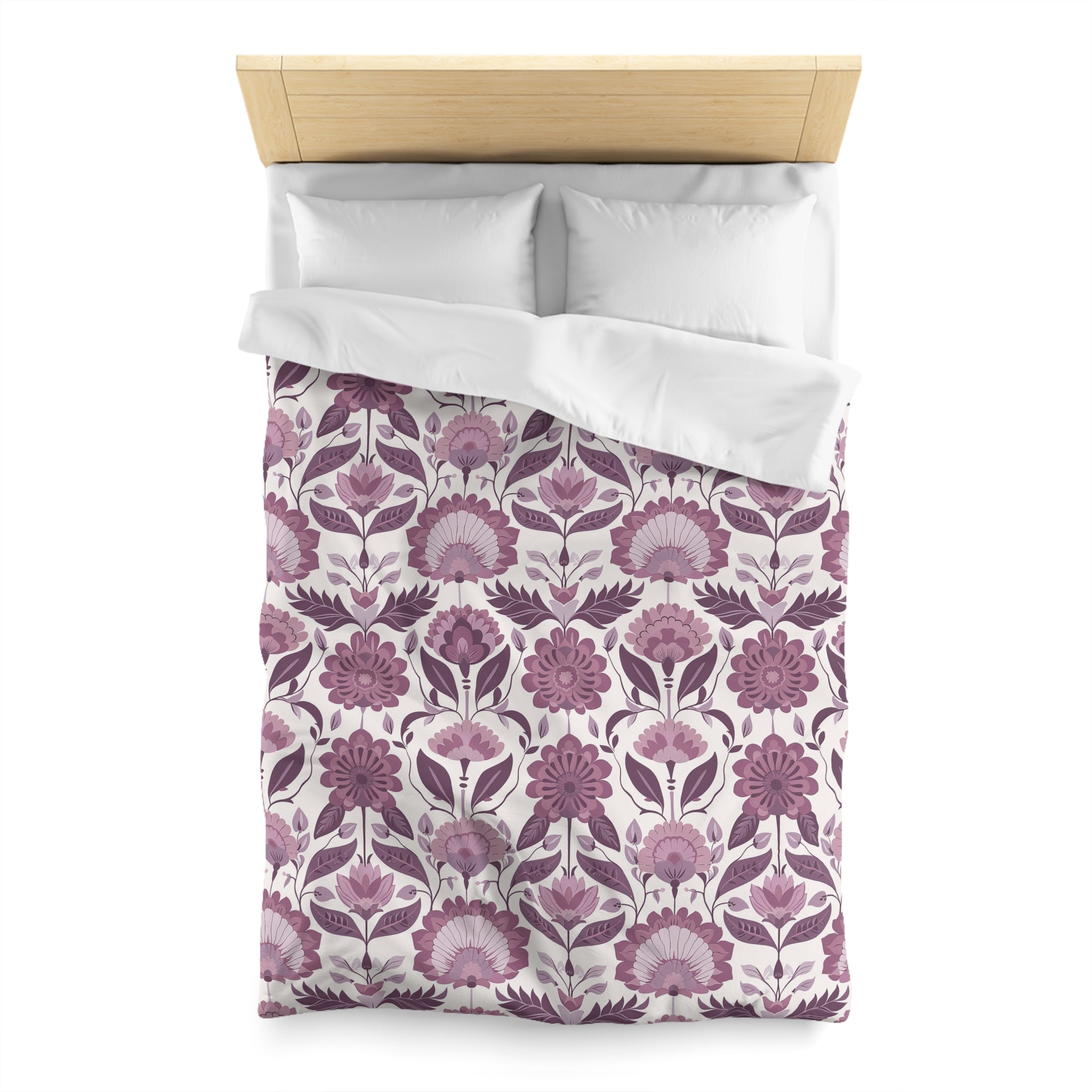 a bed with a floral patterned comforter and pillows.