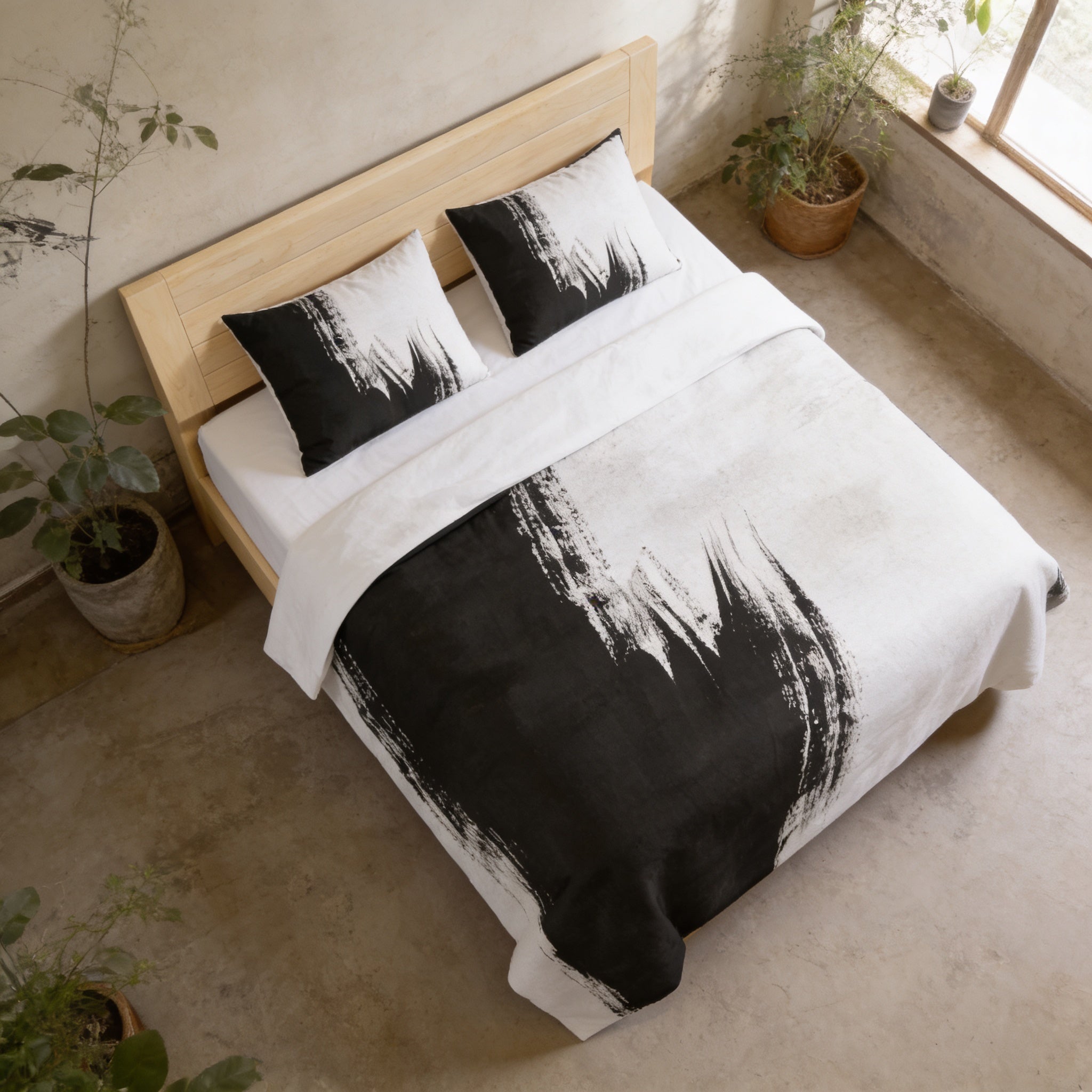 a bedroom with a bed featuring a black and white patterned comforter and pillows. The bed is positioned against a wall with a window, and there are potted plants nearby.