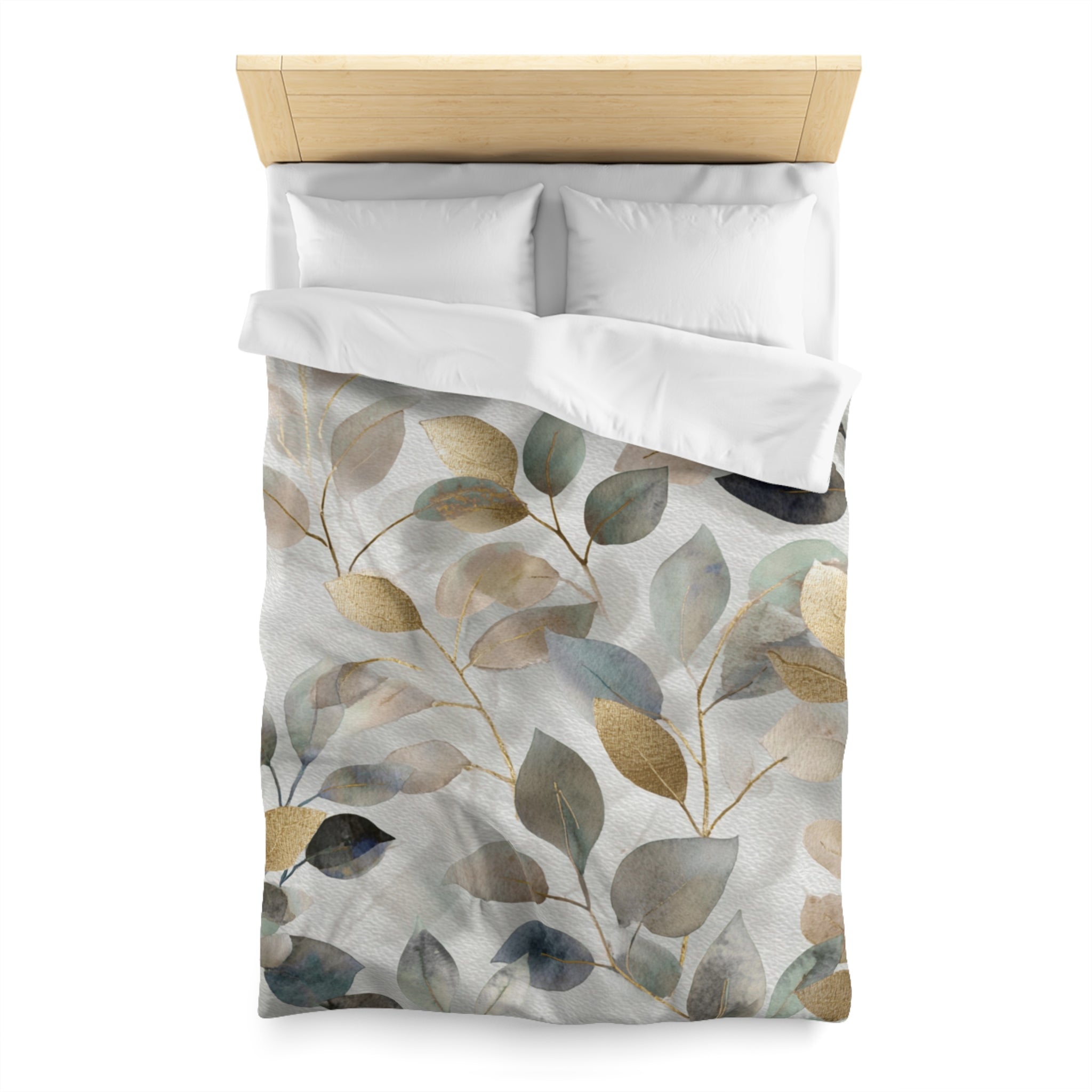 a bed with a white comforter and a decorative leaf pattern on it.