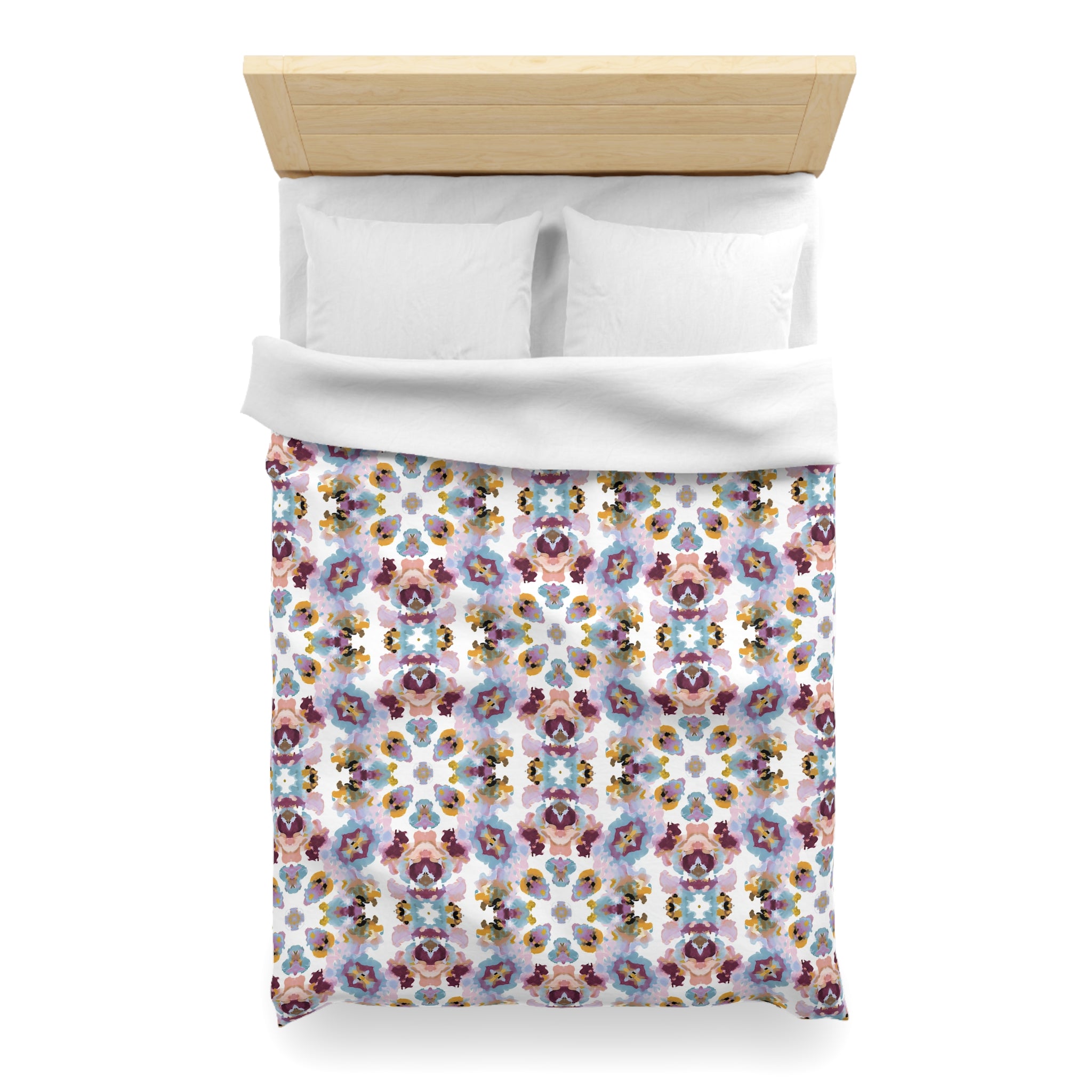 a neatly made bed with a colorful floral patterned comforter and pillows.