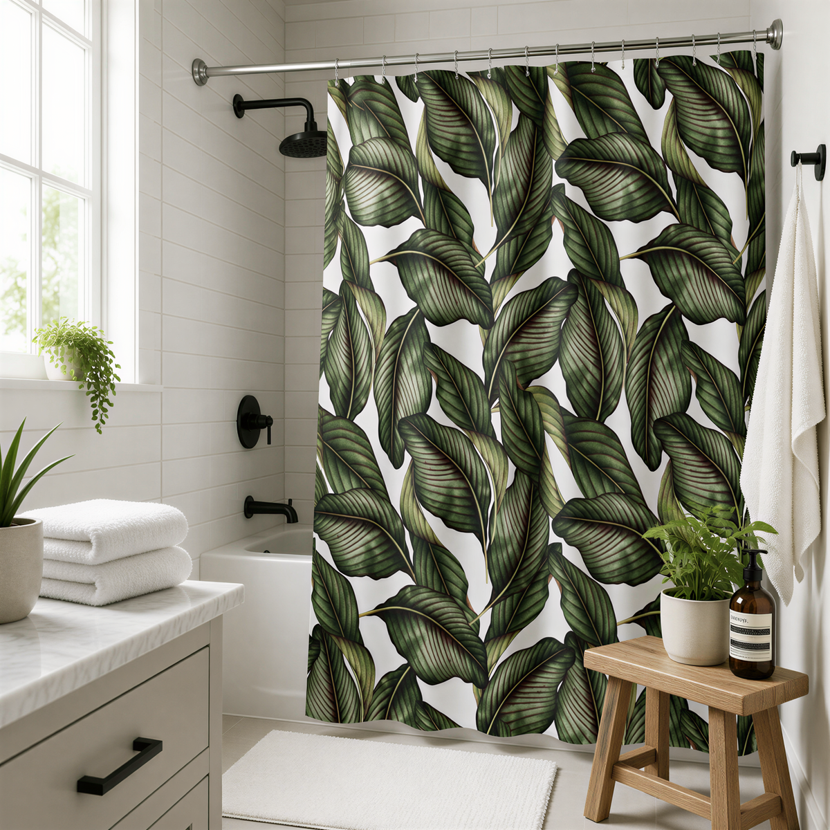 a bathroom with a shower curtain featuring a tropical leaf pattern. The bathroom is well-decorated with a wooden stool, potted plants, and a white countertop with folded towels.
