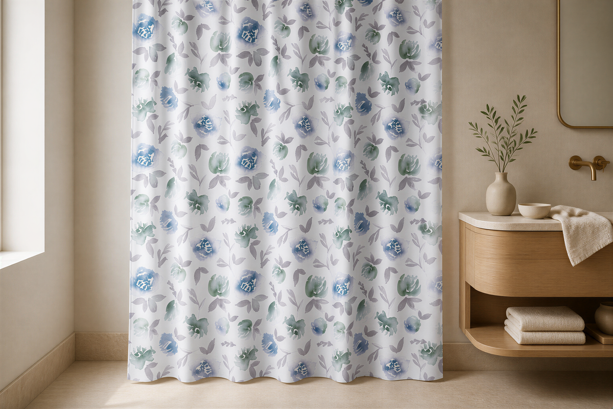 a bathroom with a shower curtain adorned with a floral pattern in shades of blue and gray. The shower curtain is hanging on a wall, and there is a wooden vanity with a mirror above it. A vase with greenery is placed on the vanity, adding a touch of nature to the space.