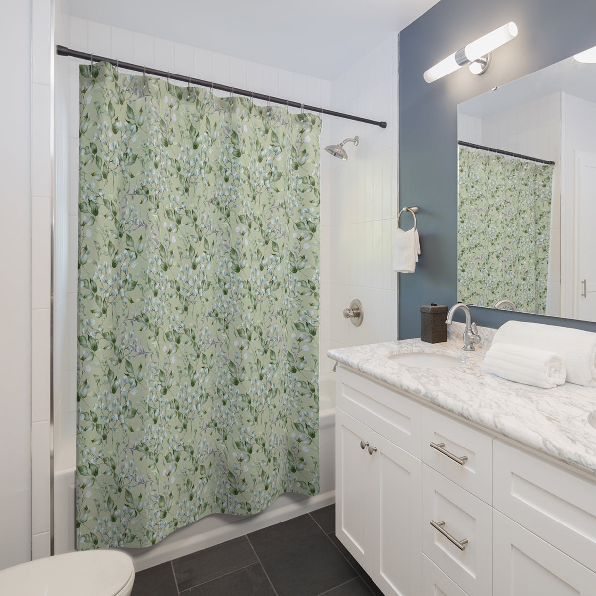 a modern bathroom with a white vanity, a green shower curtain with a floral pattern, and a mirror above the sink.