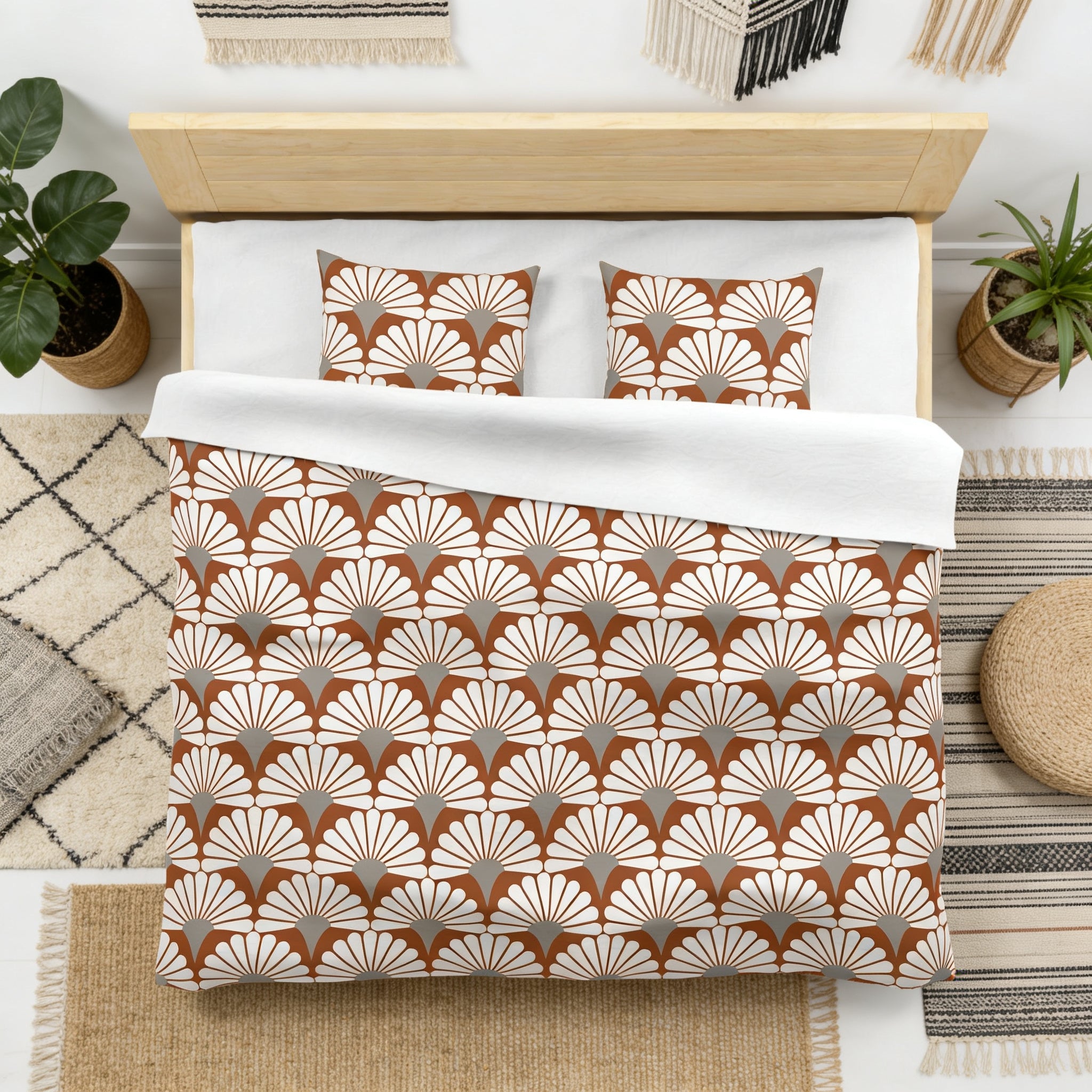 a neatly made bed with a patterned comforter and pillows, surrounded by various decorative elements such as potted plants and rugs.