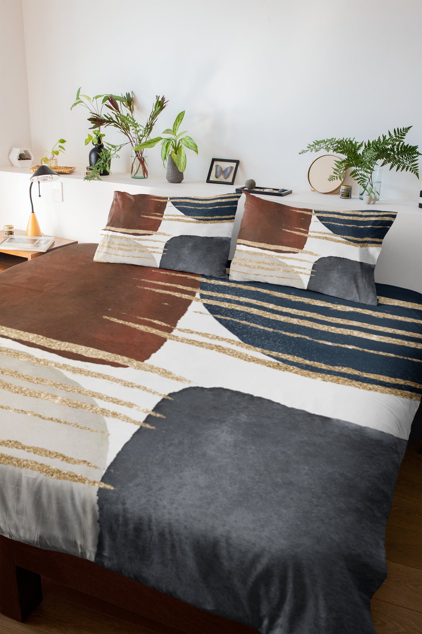 a bed with a brown and blue comforter and pillows