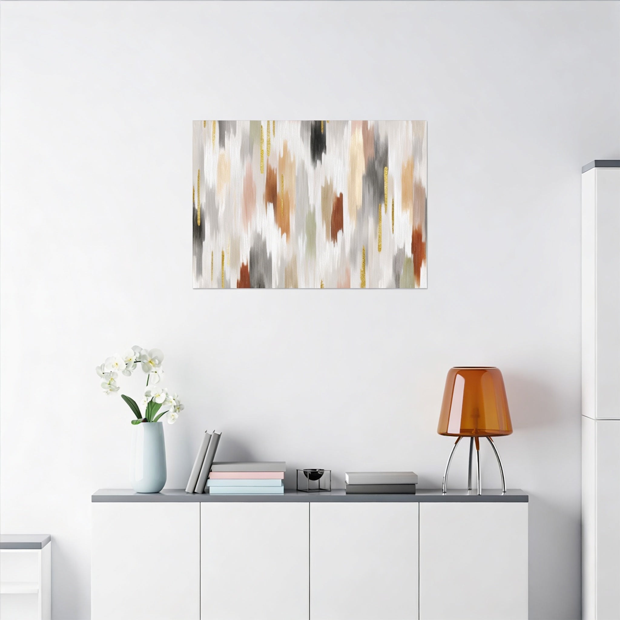a minimalist living space with a white wall, a wooden cabinet, a vase with white flowers, a stack of books, and a lamp on a white shelf.