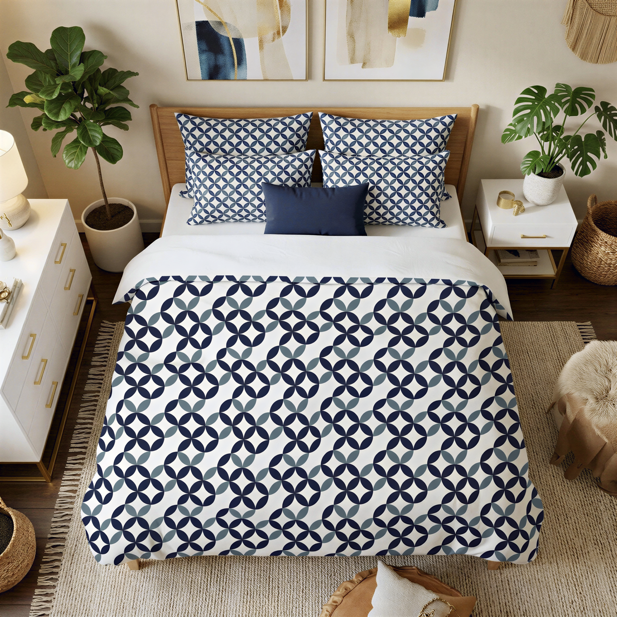 a well-decorated bedroom with a large bed featuring a blue and white patterned comforter and pillows. The bed is surrounded by a white dresser, a nightstand, and a potted plant. The room also includes a rug and a painting on the wall.