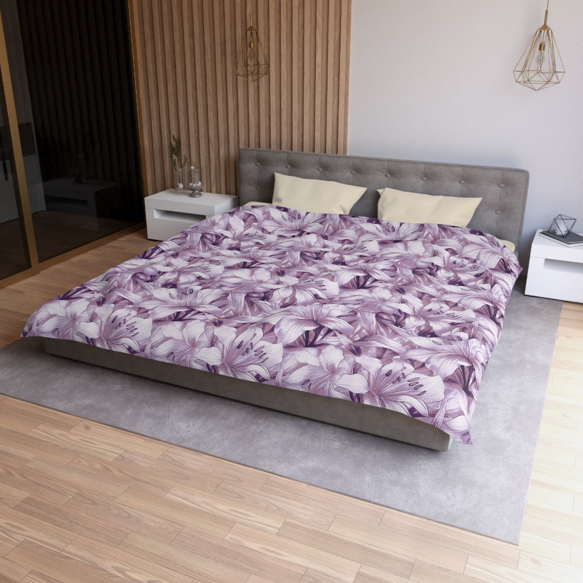 a modern bedroom with a large bed covered in a purple floral comforter. The bed is positioned against a wall with a wooden panel. The room also features a nightstand, a rug, and a pendant light fixture.