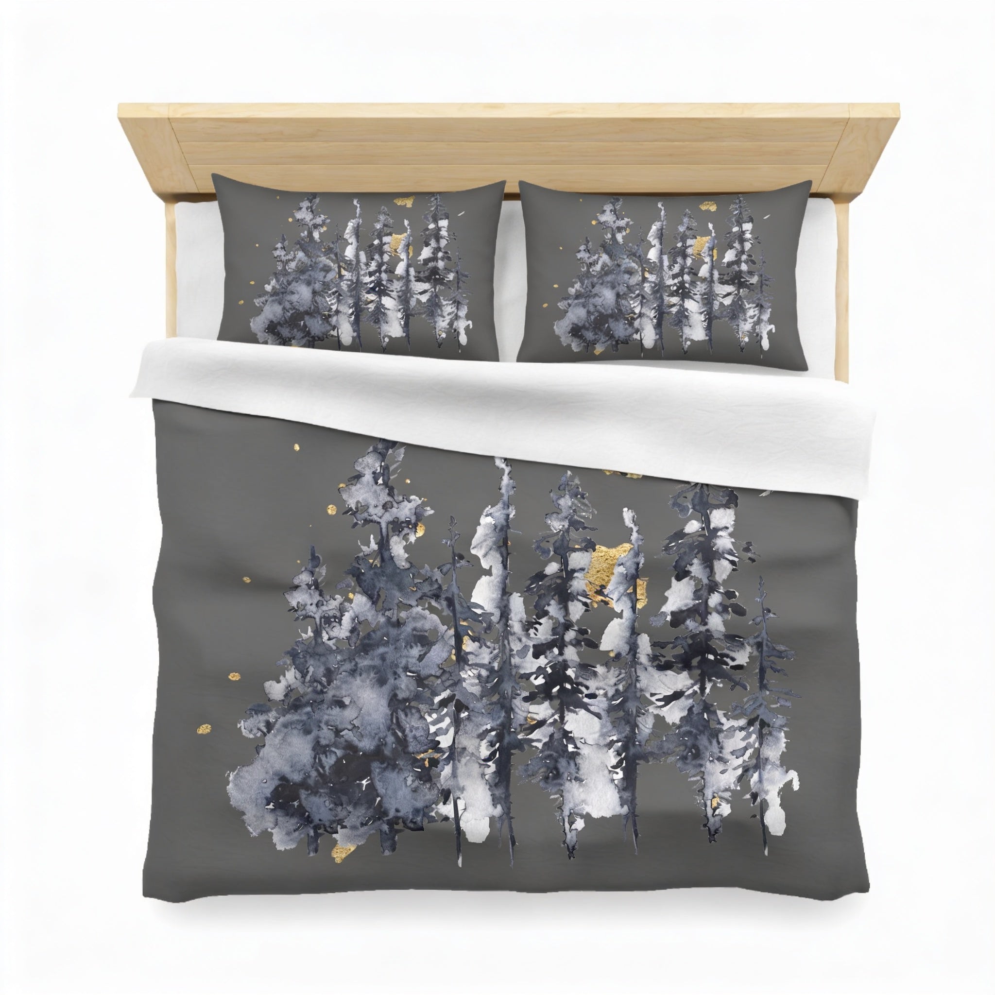 a bed with a gray and white duvet cover featuring a design of trees with a watercolor-like effect.