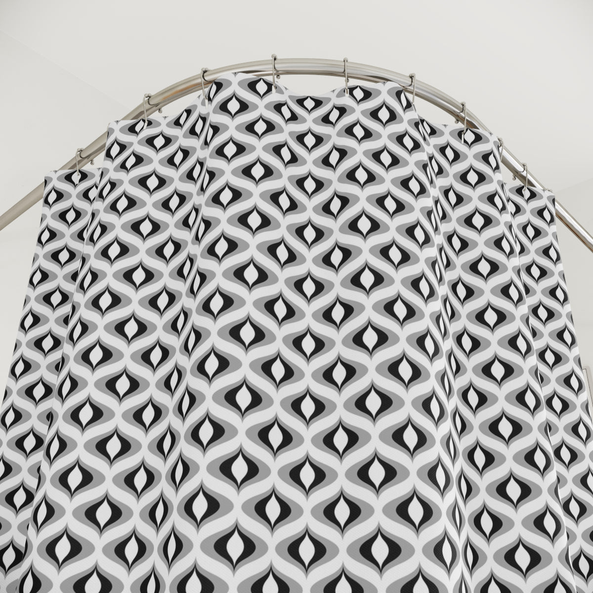 a shower curtain with a repeating pattern of black and white geometric shapes, creating a visually striking and modern design.