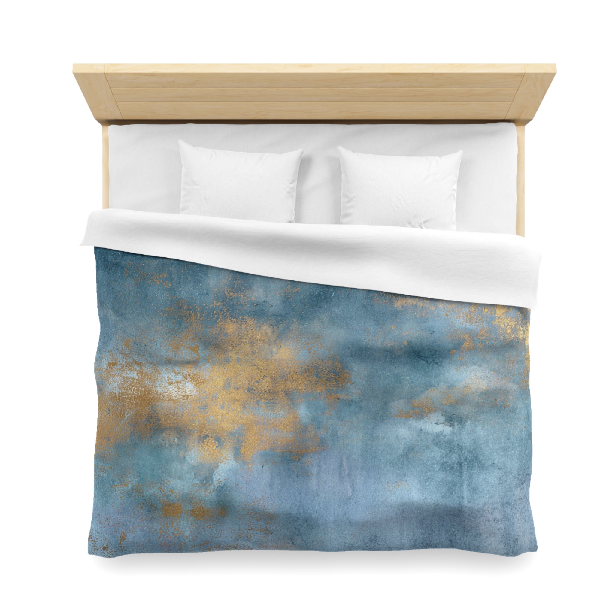 a bed with a blue and gold patterned comforter and white pillows.
