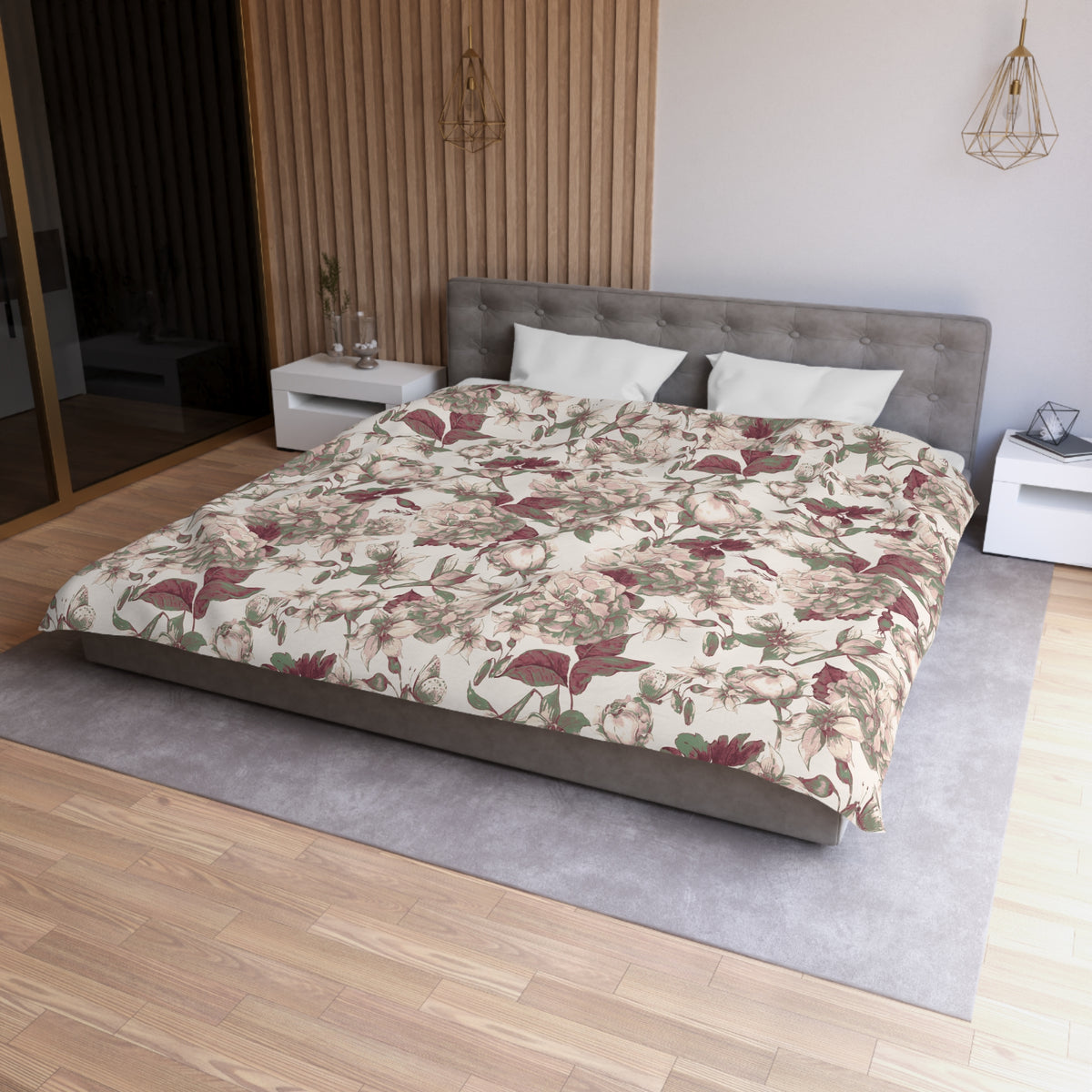 a modern bedroom with a large bed, a gray headboard, and a floral patterned comforter. The room has a wooden floor and white walls, creating a serene and elegant atmosphere.