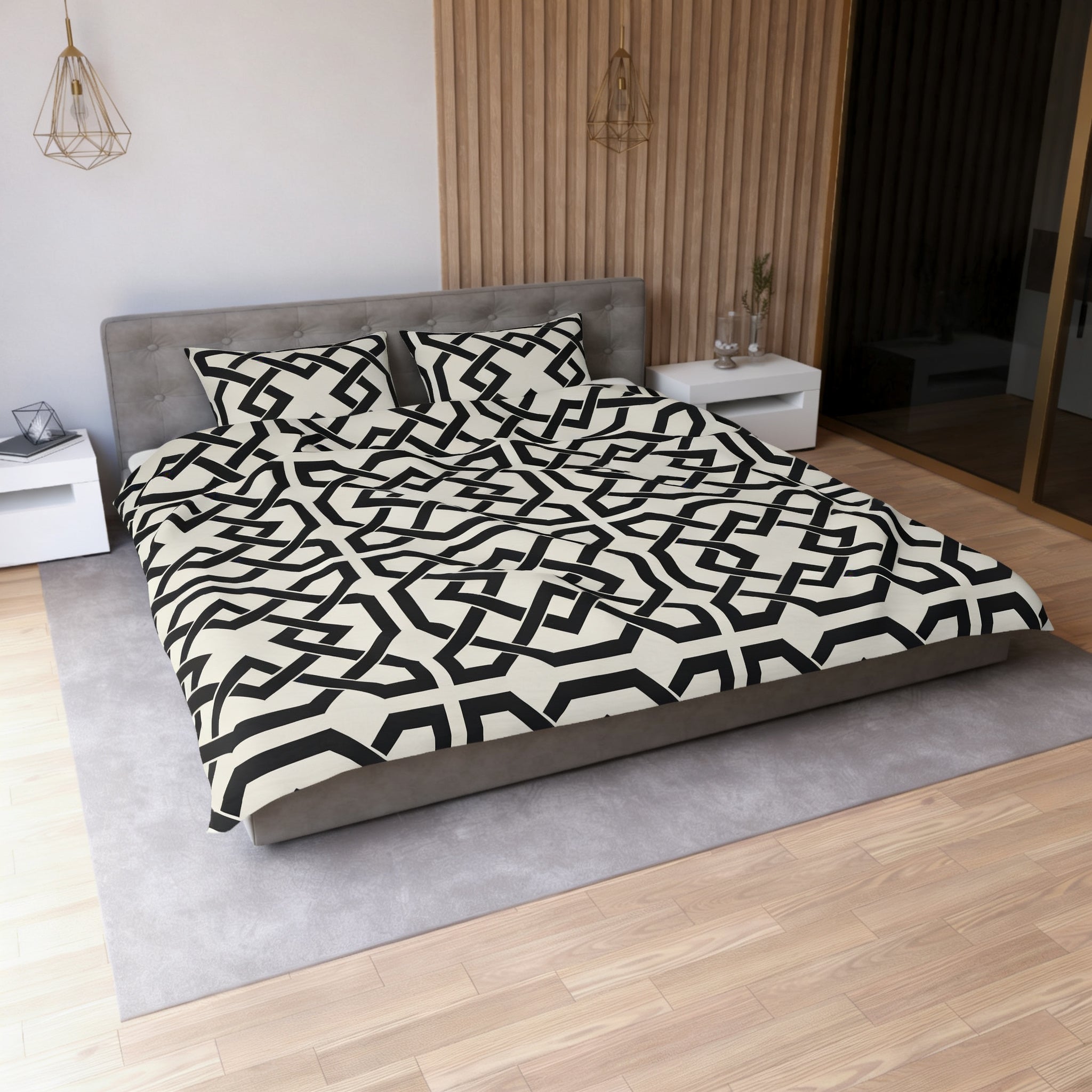 a modern bedroom with a large bed covered in a black and white geometric patterned comforter and pillows. The bed is positioned against a wall with a wooden paneled accent wall. The room also includes a nightstand and a pendant light fixture.
