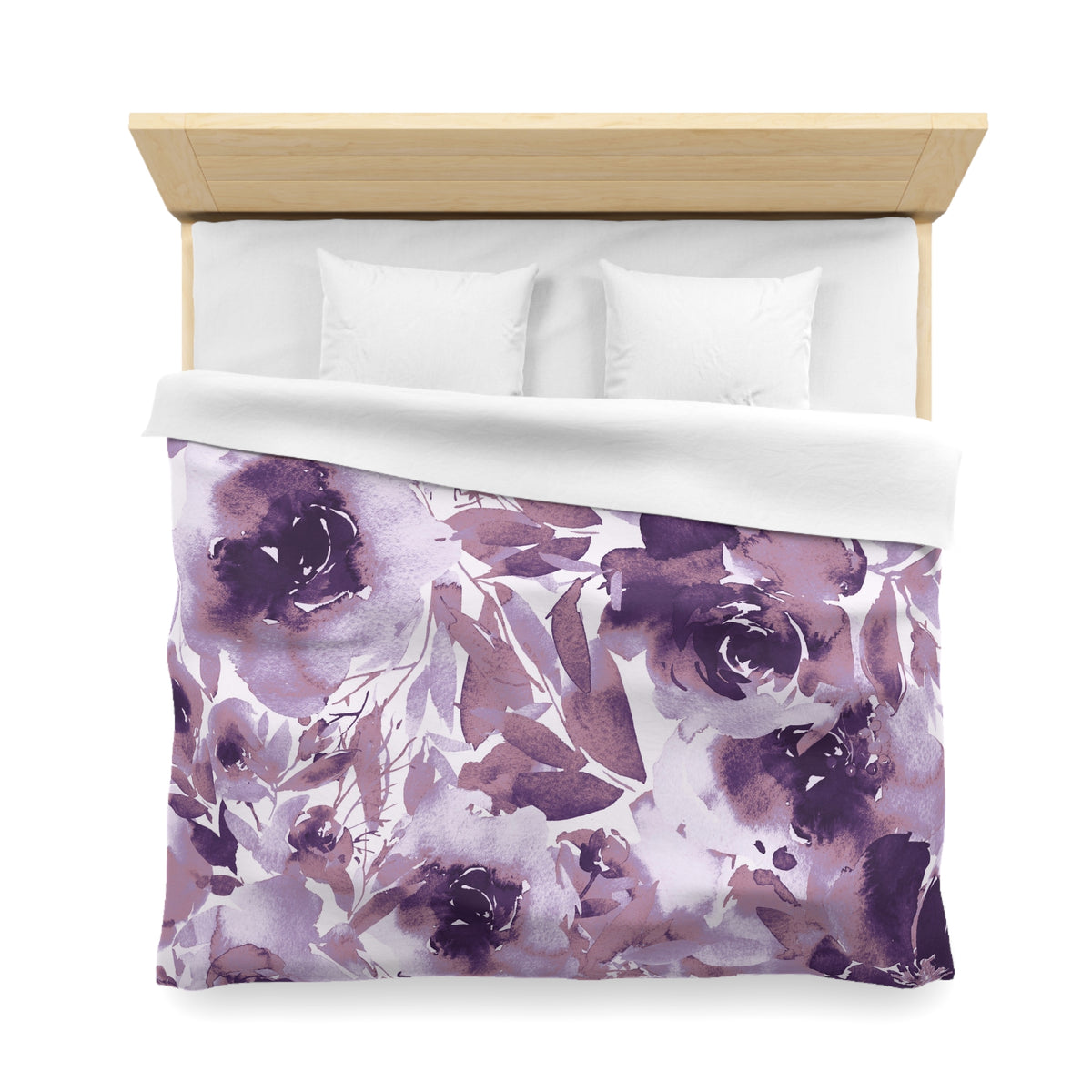 a bed with a floral print duvet cover and pillows.