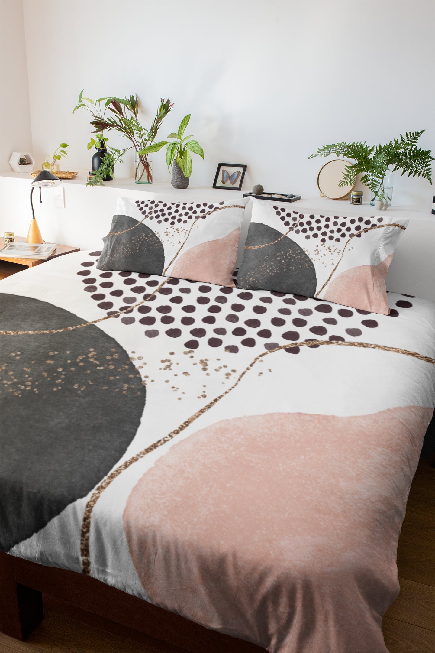 a bed with a pink and black comforter and pillows