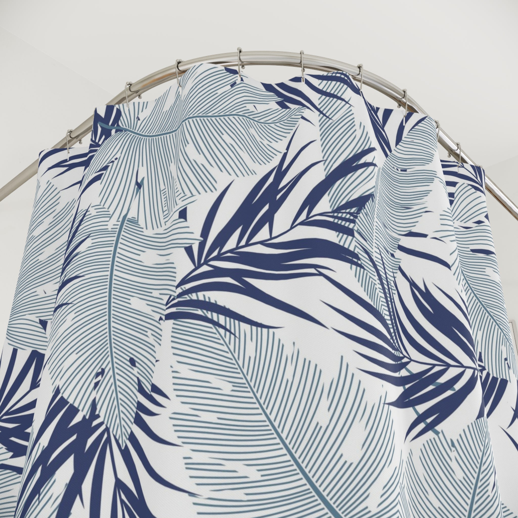 a shower curtain with a tropical leaf pattern in shades of blue and white.