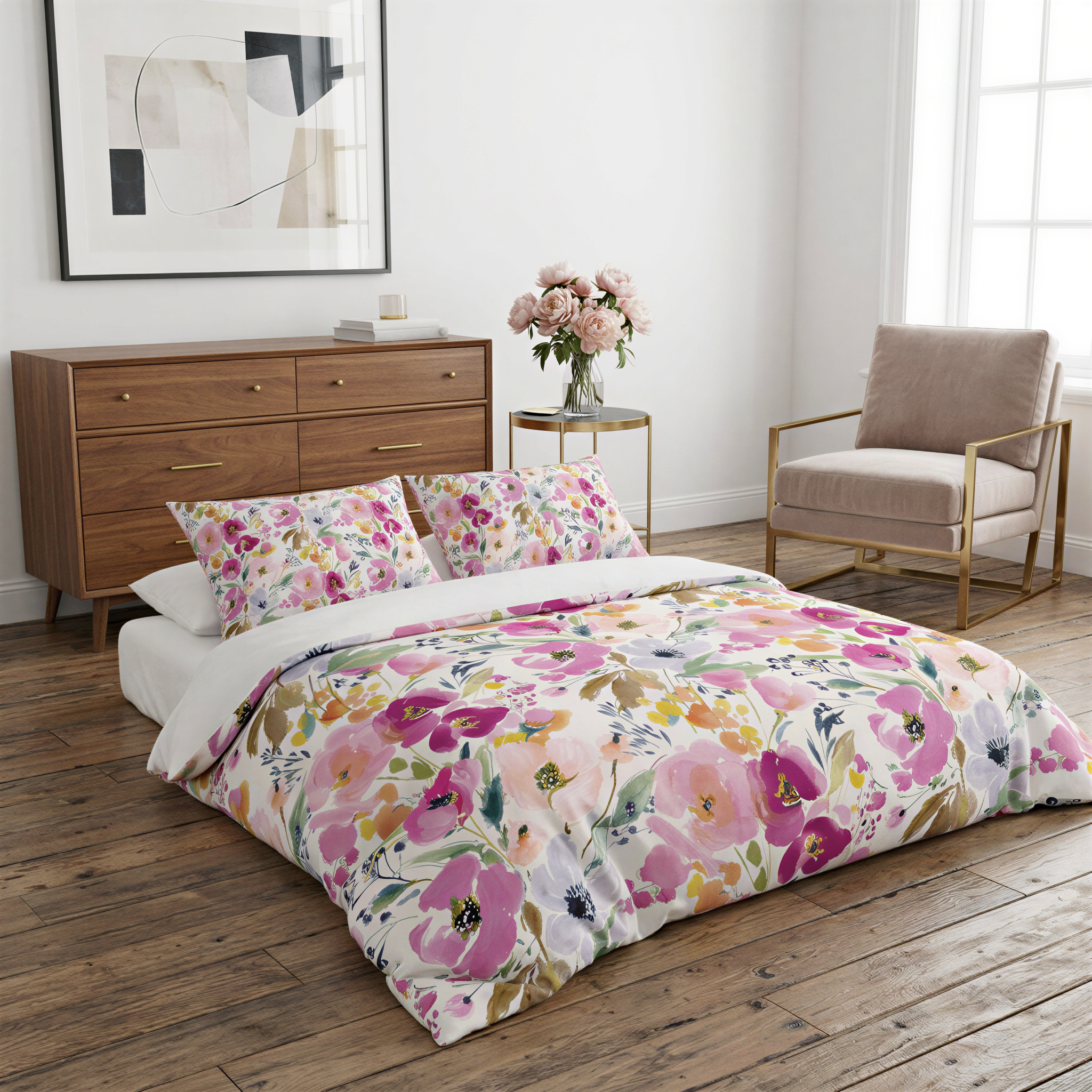 a bedroom with a floral-patterned bedspread, a wooden dresser, a vase of flowers, and a chair.