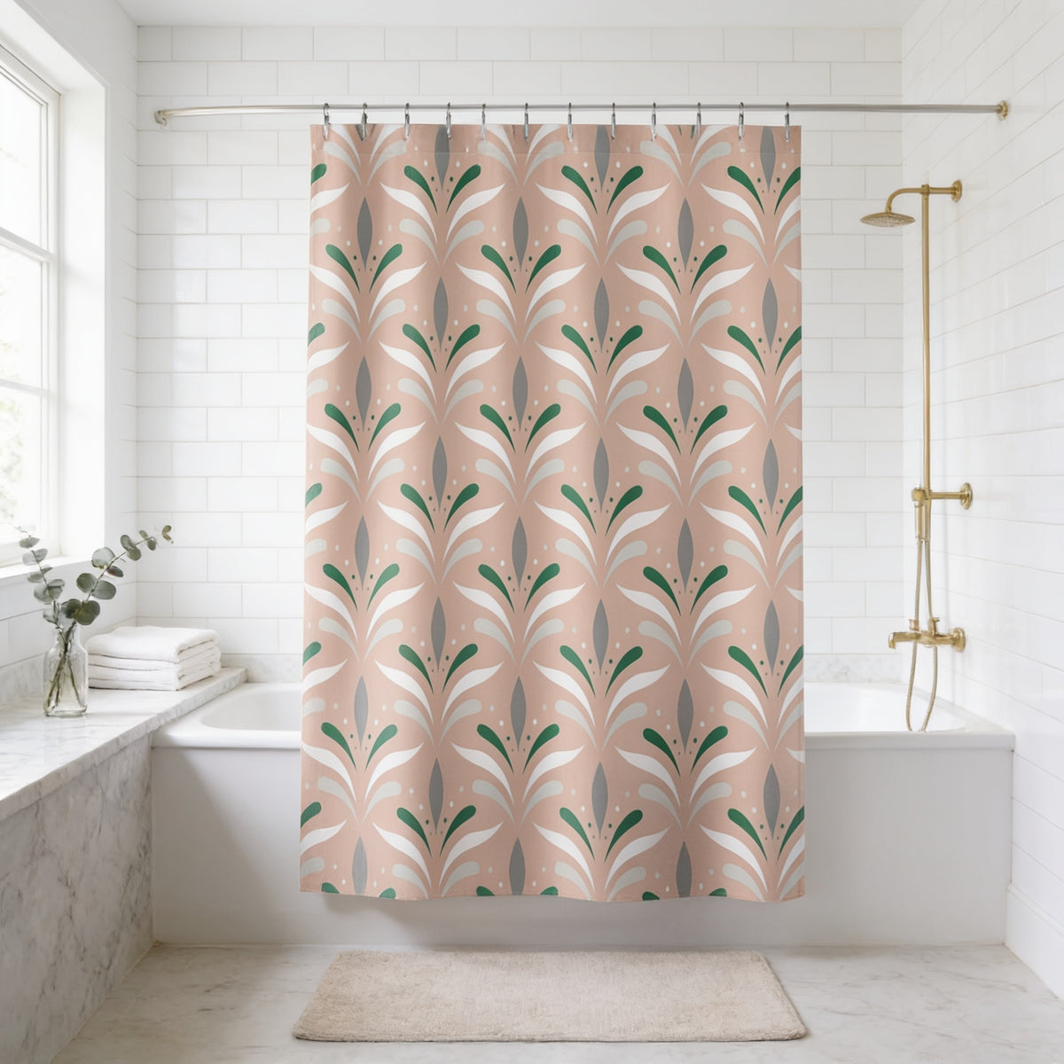 a bathroom with a shower curtain featuring a repeating pattern of green and white leaves. The shower curtain is hanging from a rod above a white bathtub. The bathroom has white tiled walls and a white marble countertop. There is a window in the background, and a rug is placed on the floor in front of the bathtub.