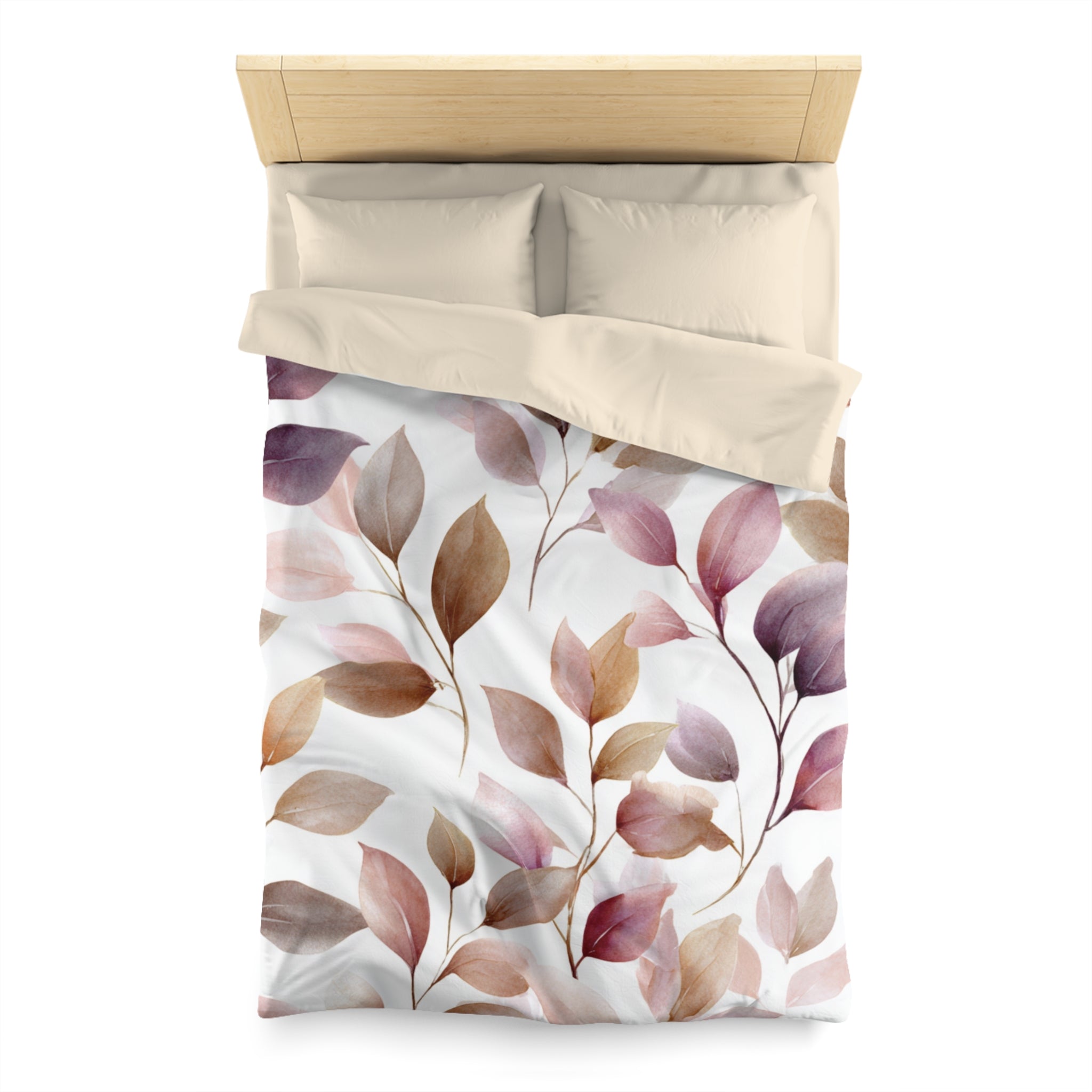 a bed with a white comforter and a leaf-patterned duvet cover.