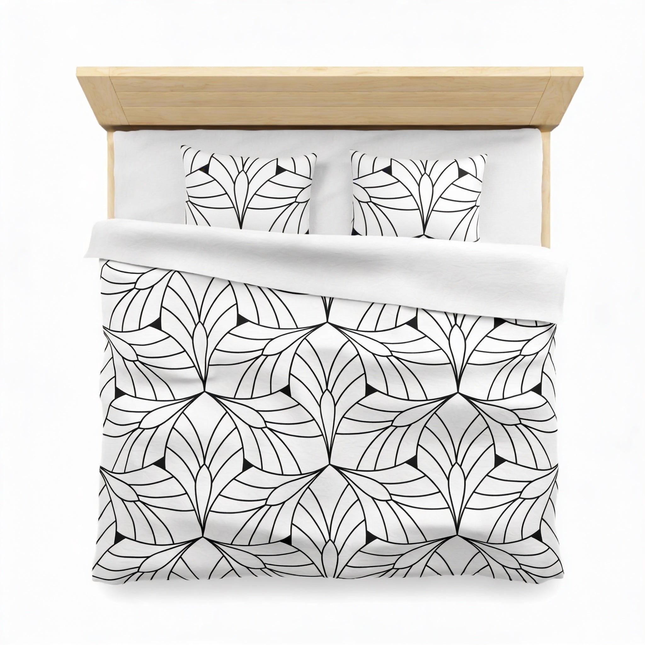 a neatly made bed with a black and white geometric patterned comforter and matching pillows.