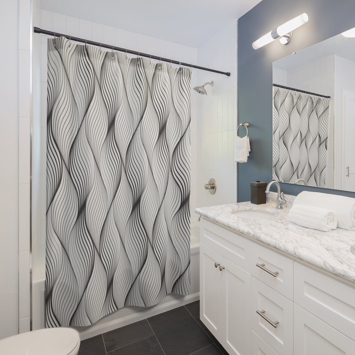 a modern bathroom with a white vanity, a shower curtain with a black and white wave pattern, and a mirror above the vanity.