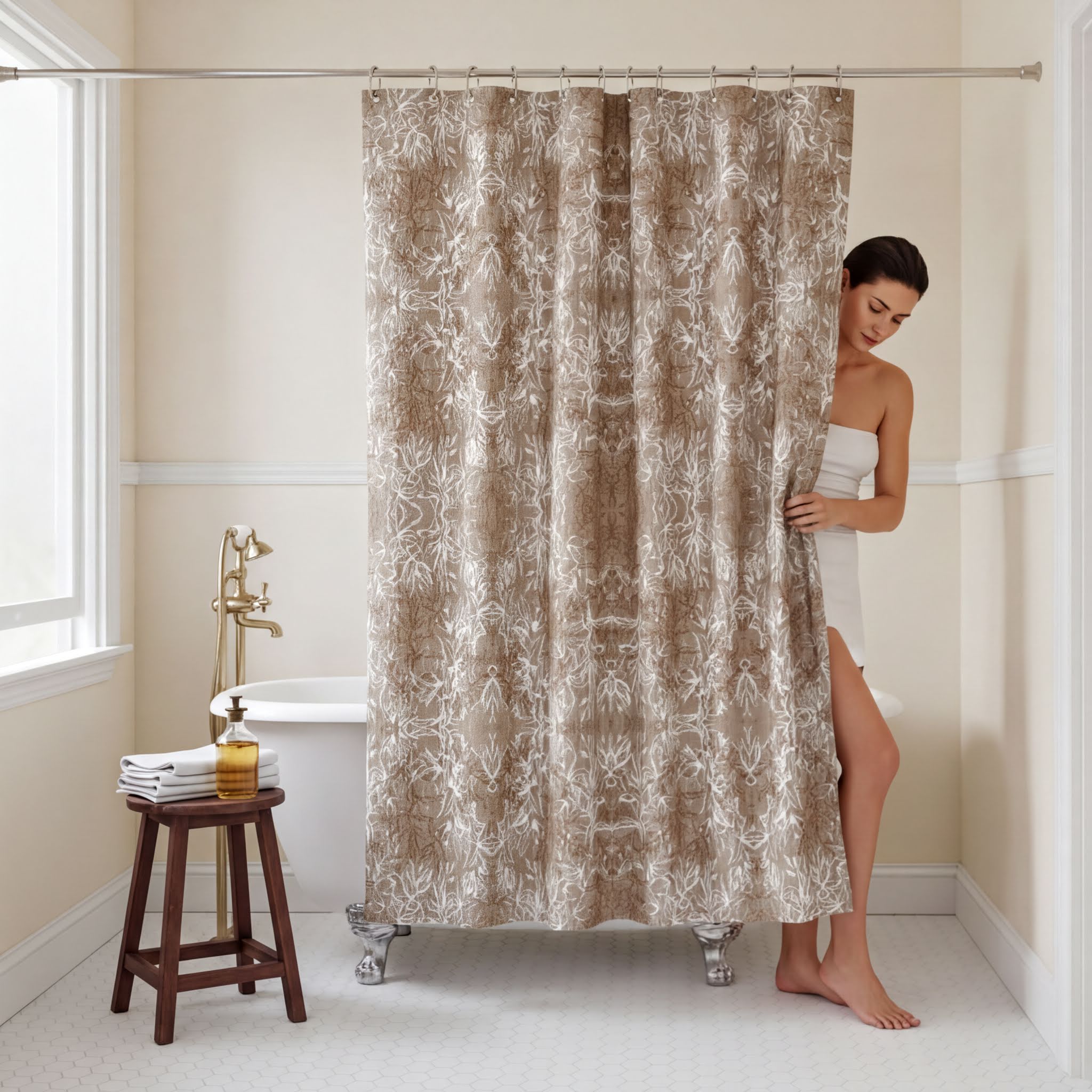 A woman stands in a bathroom, partially obscured by a beige shower curtain with a floral pattern. The bathroom has a white bathtub, a wooden stool, and a bottle of soap on the floor.