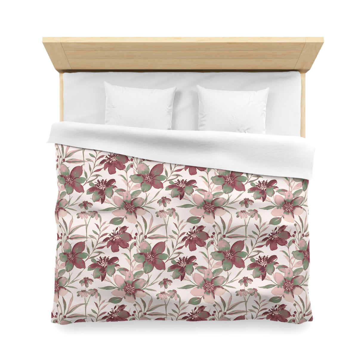 a neatly made bed with a floral patterned comforter and pillows.