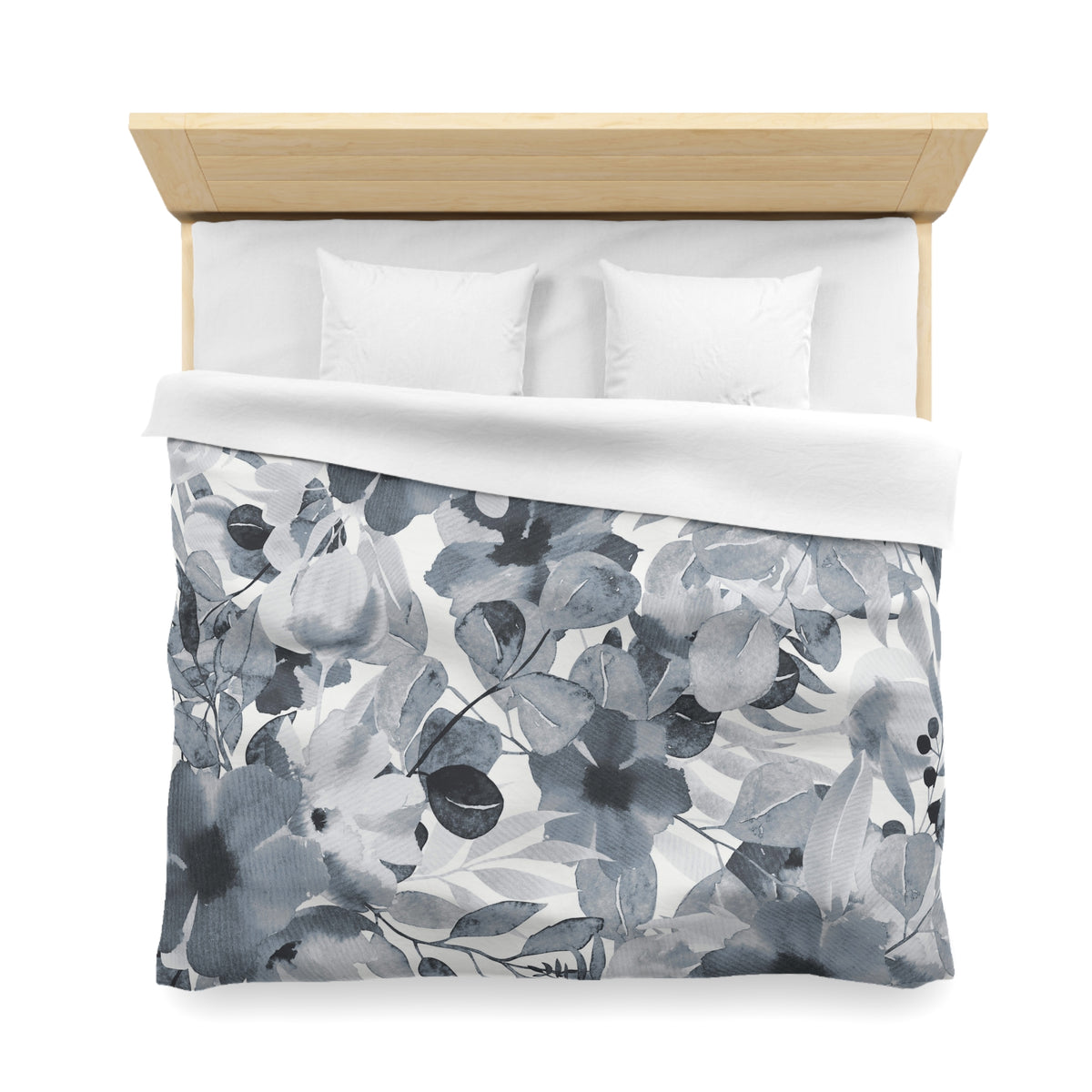 a neatly made bed with a floral print duvet cover and two white pillows.