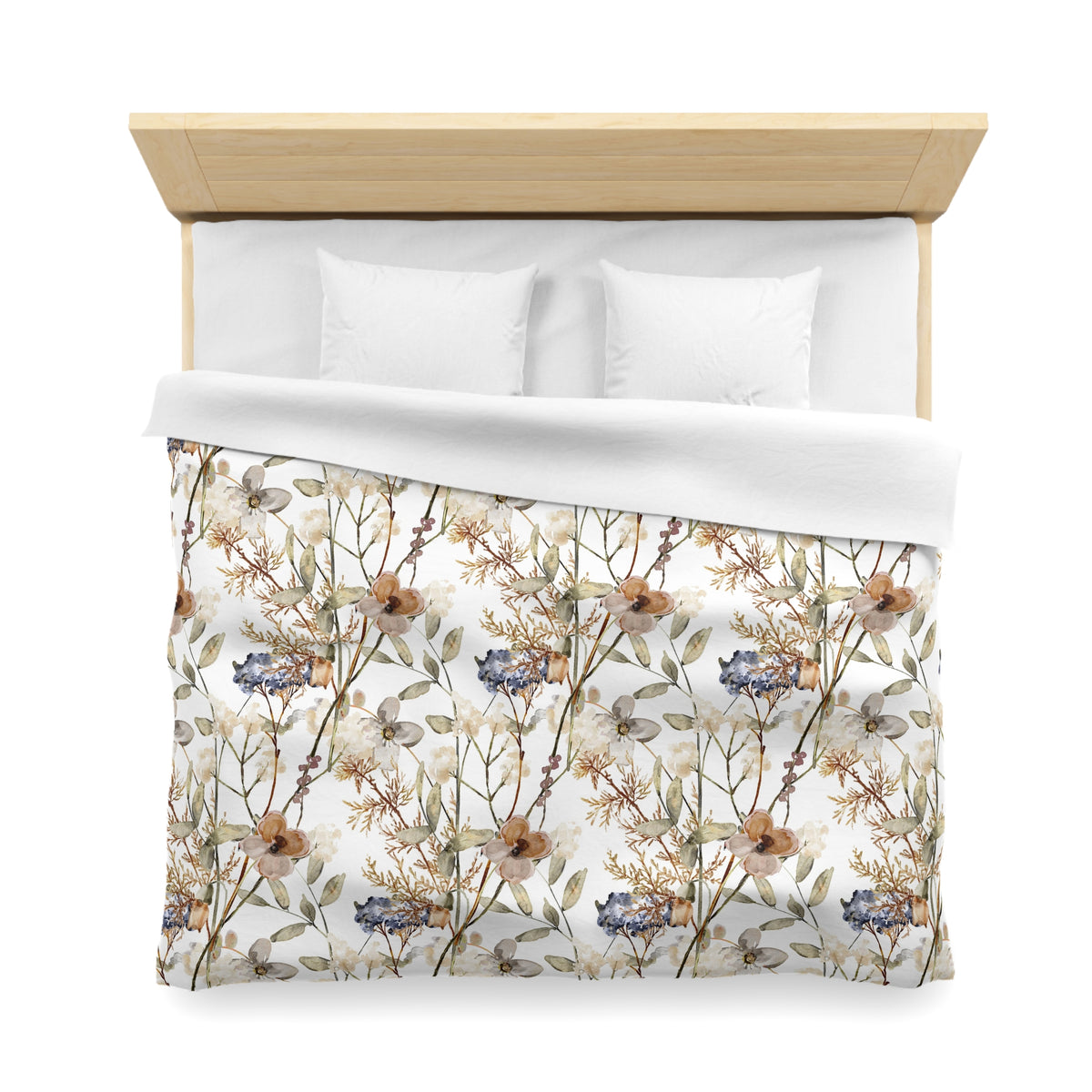 a neatly made bed with a floral print comforter and two white pillows.