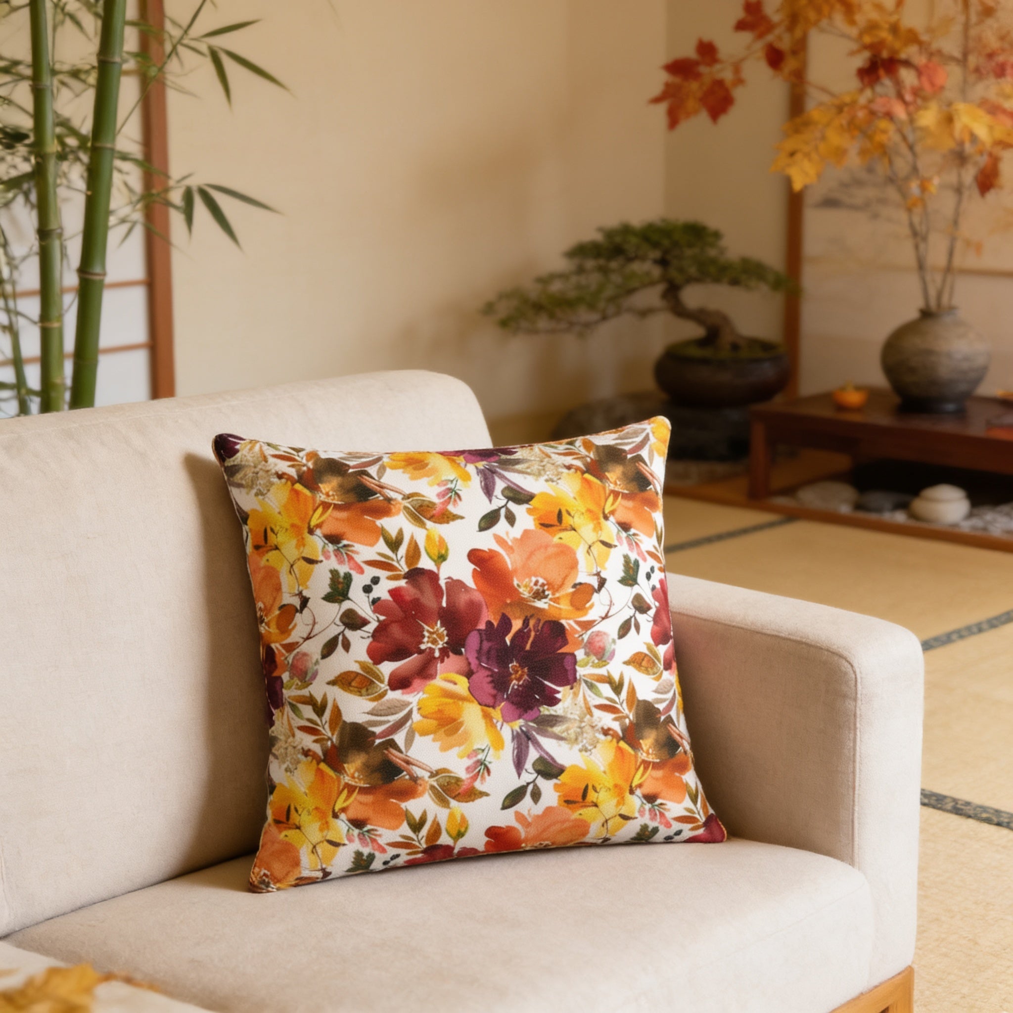 a cozy living room with a beige sofa adorned with a vibrant floral throw pillow. The room is decorated with various plants, including a bamboo plant and a bonsai tree, adding a touch of nature to the space. The arrangement of the furniture and the presence of the plants create a warm and inviting atmosphere.