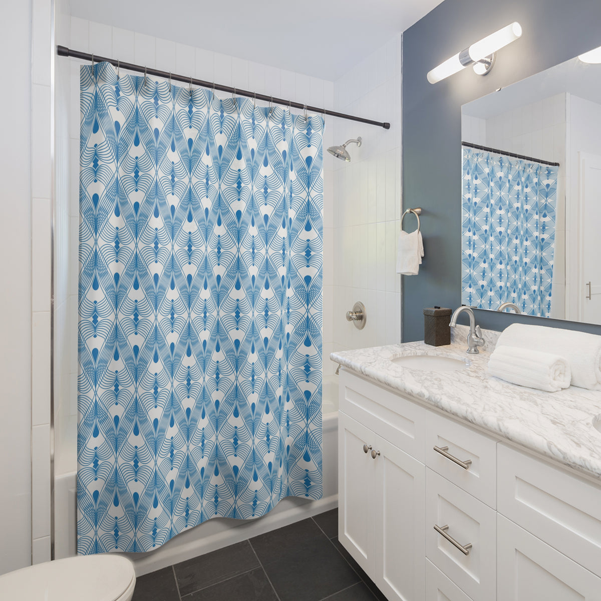 a modern bathroom with a white vanity, a blue patterned shower curtain, and a white sink.