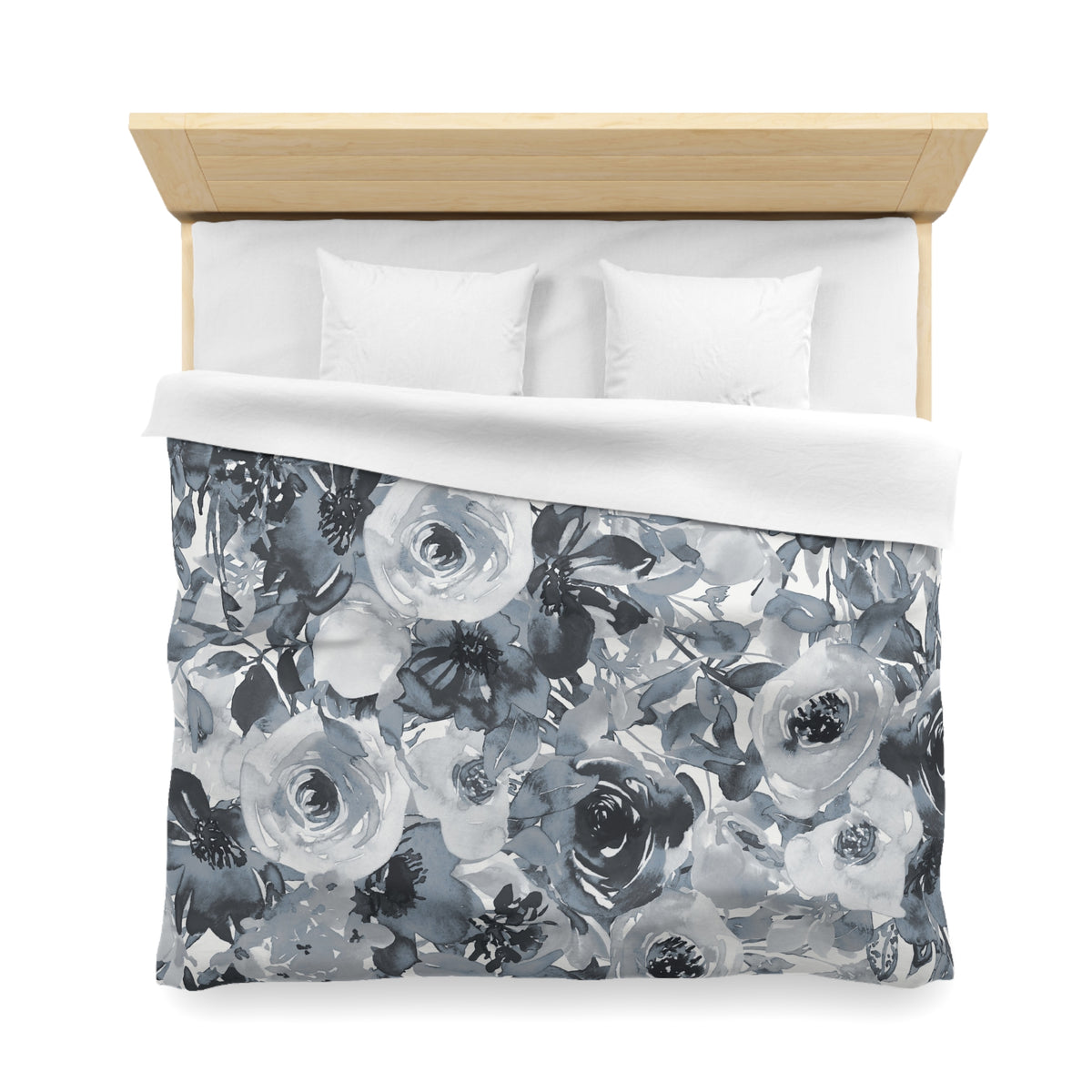a bed with a floral patterned duvet cover and white pillows.