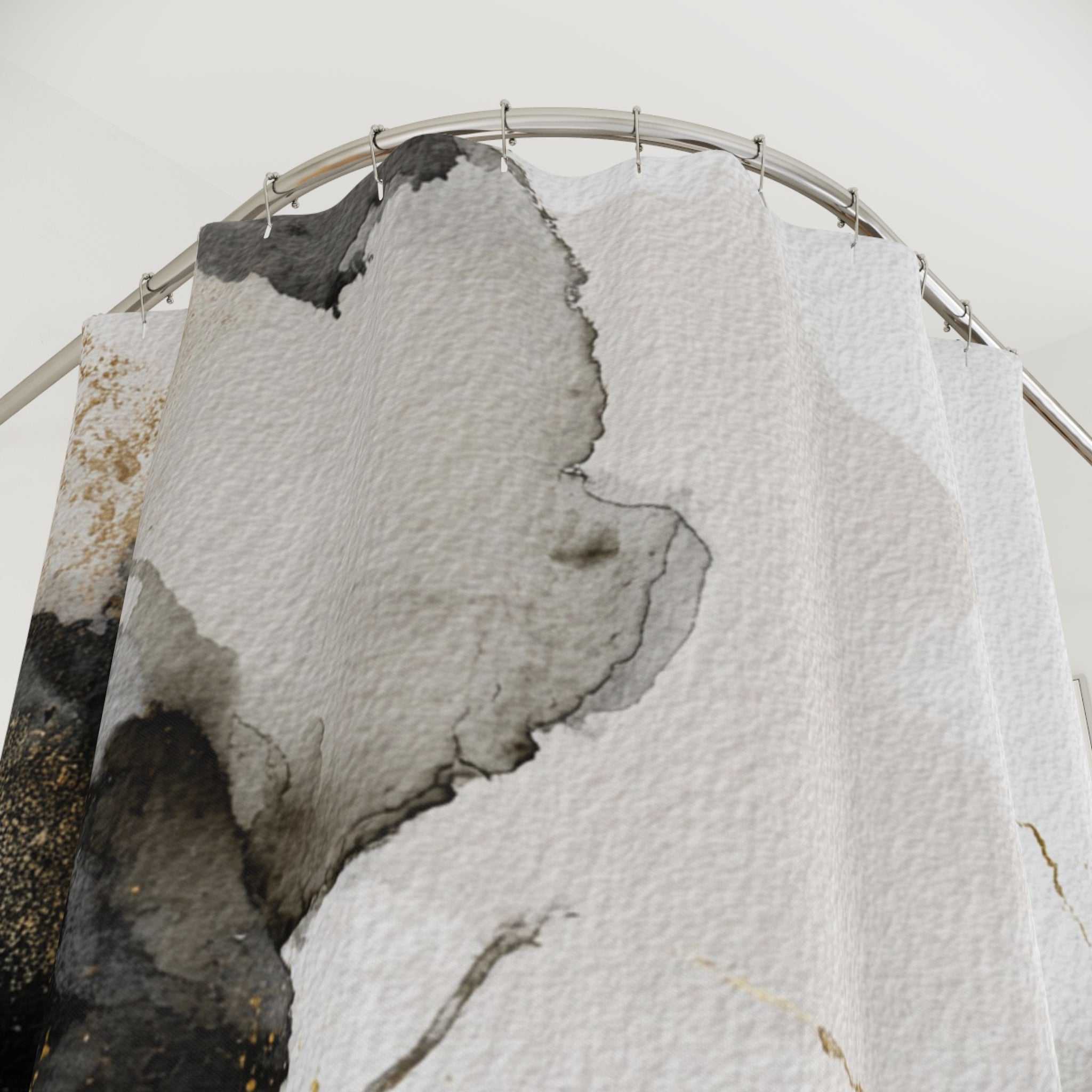 a shower curtain with a black and white abstract design, hanging from a metal rod.