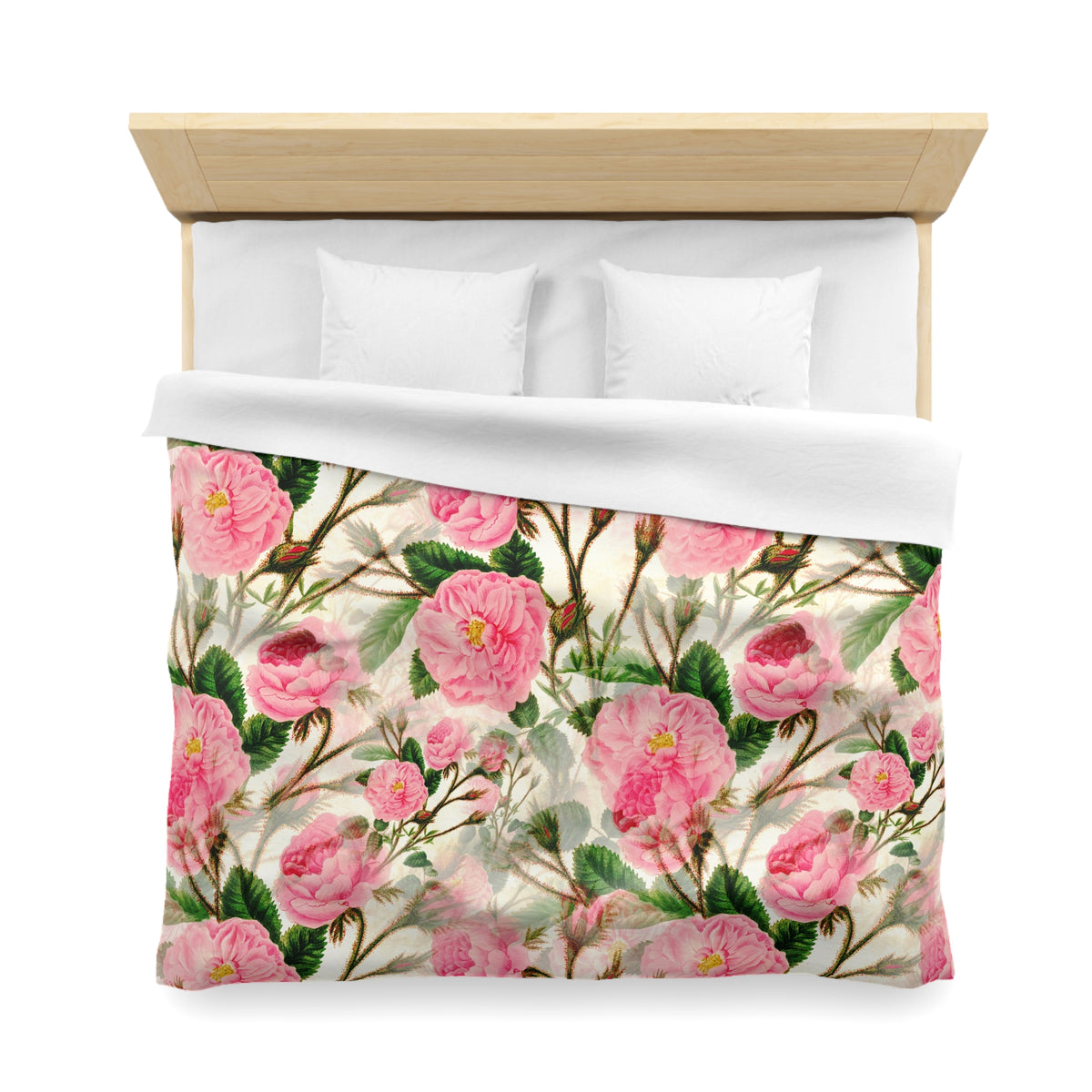 a bed with a floral print duvet cover featuring pink flowers and green leaves.