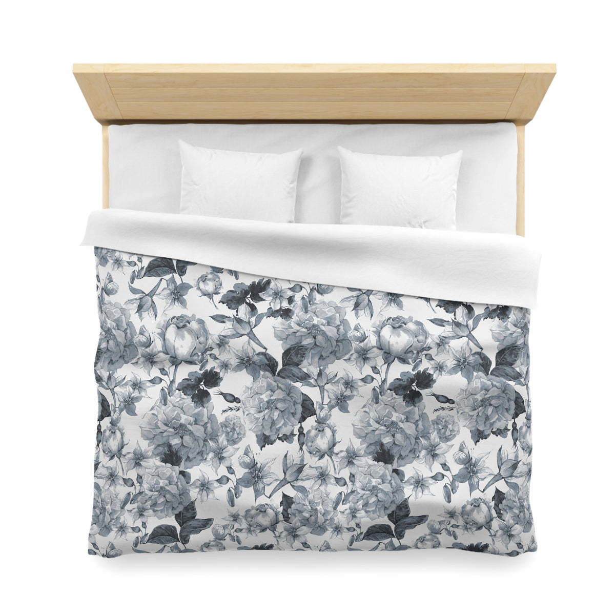 a neatly made bed with a floral print duvet cover and two white pillows.