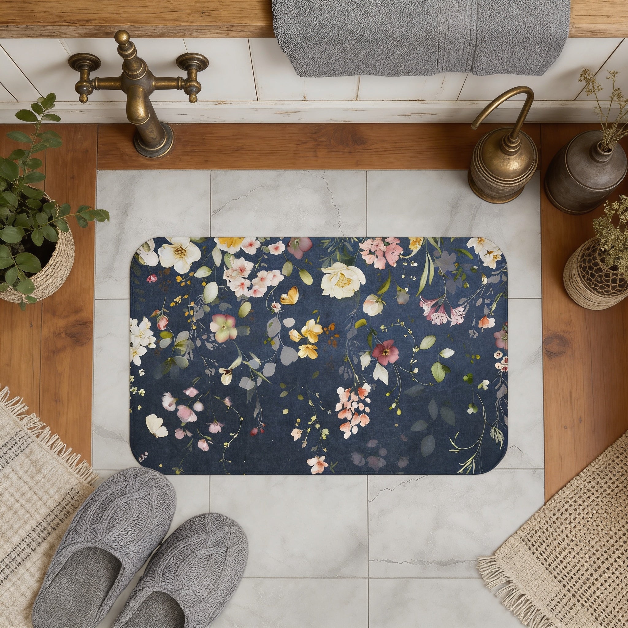 a bathroom with a floral patterned bath mat, a pair of gray slippers, and various decorative elements such as potted plants and a towel.
