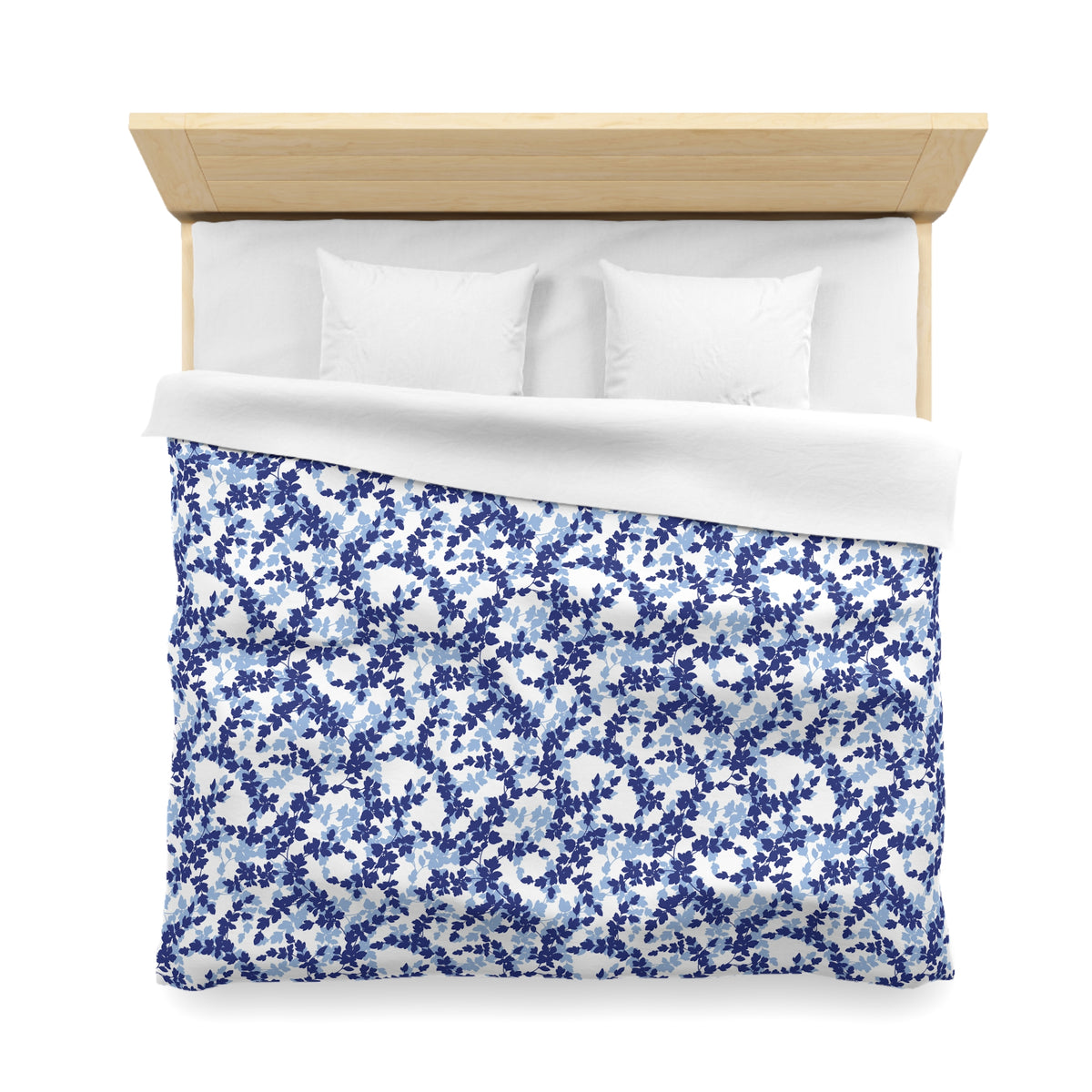 a neatly made bed with a blue and white floral patterned comforter and two white pillows.