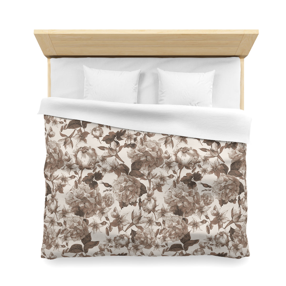 a neatly made bed with a floral patterned comforter and two white pillows.