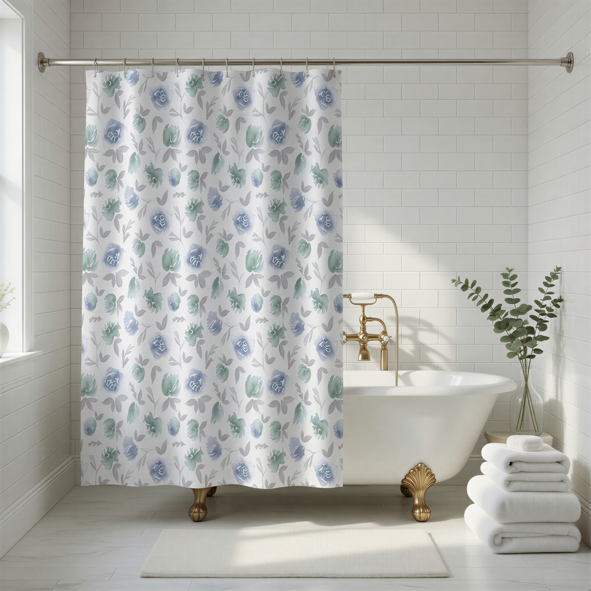 A white freestanding bathtub with gold fixtures, surrounded by white towels and a blue and white floral shower curtain.